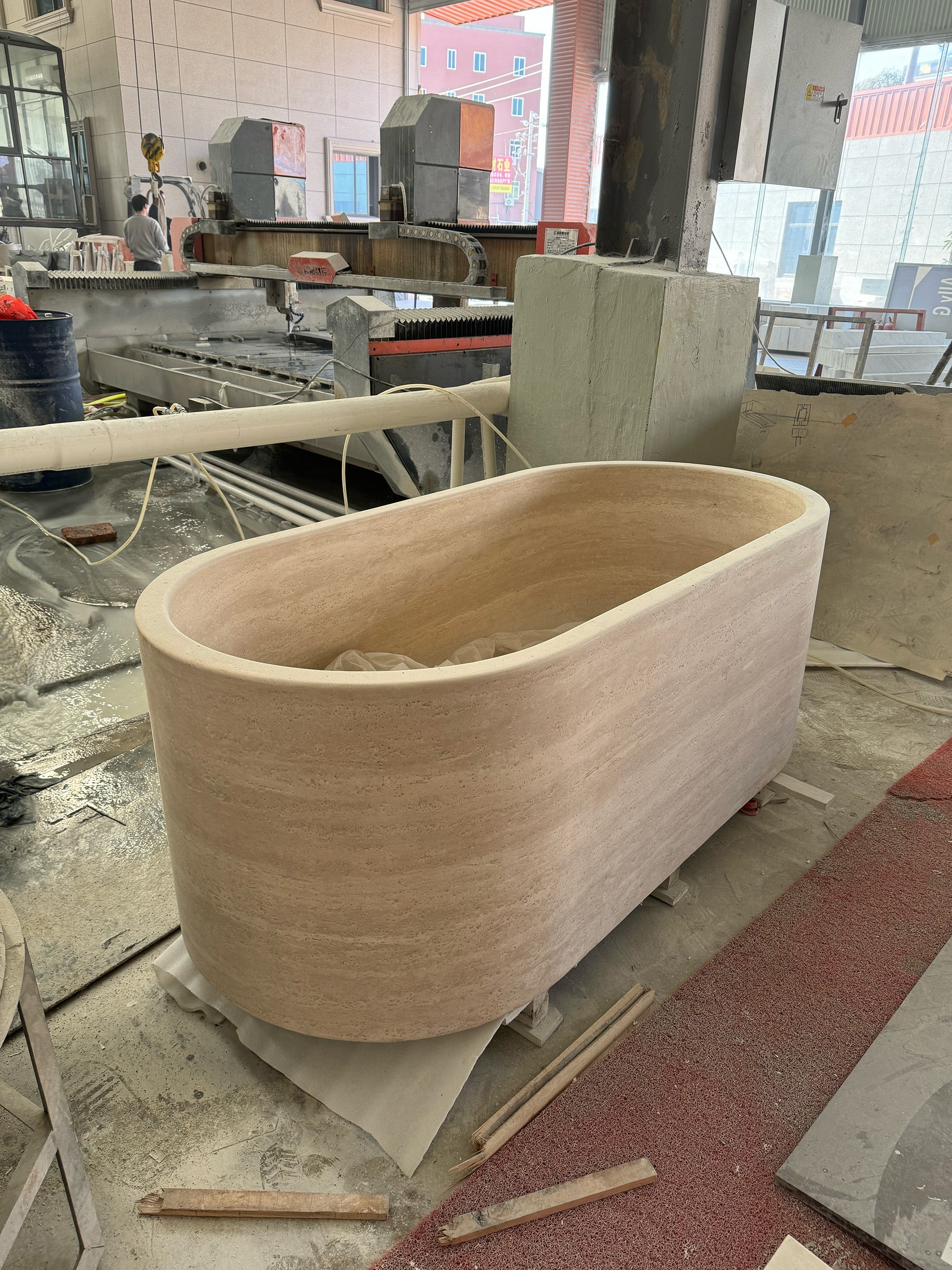 Monolithic Travertine marble bathtub with elliptical silhouette by GustavDesign.