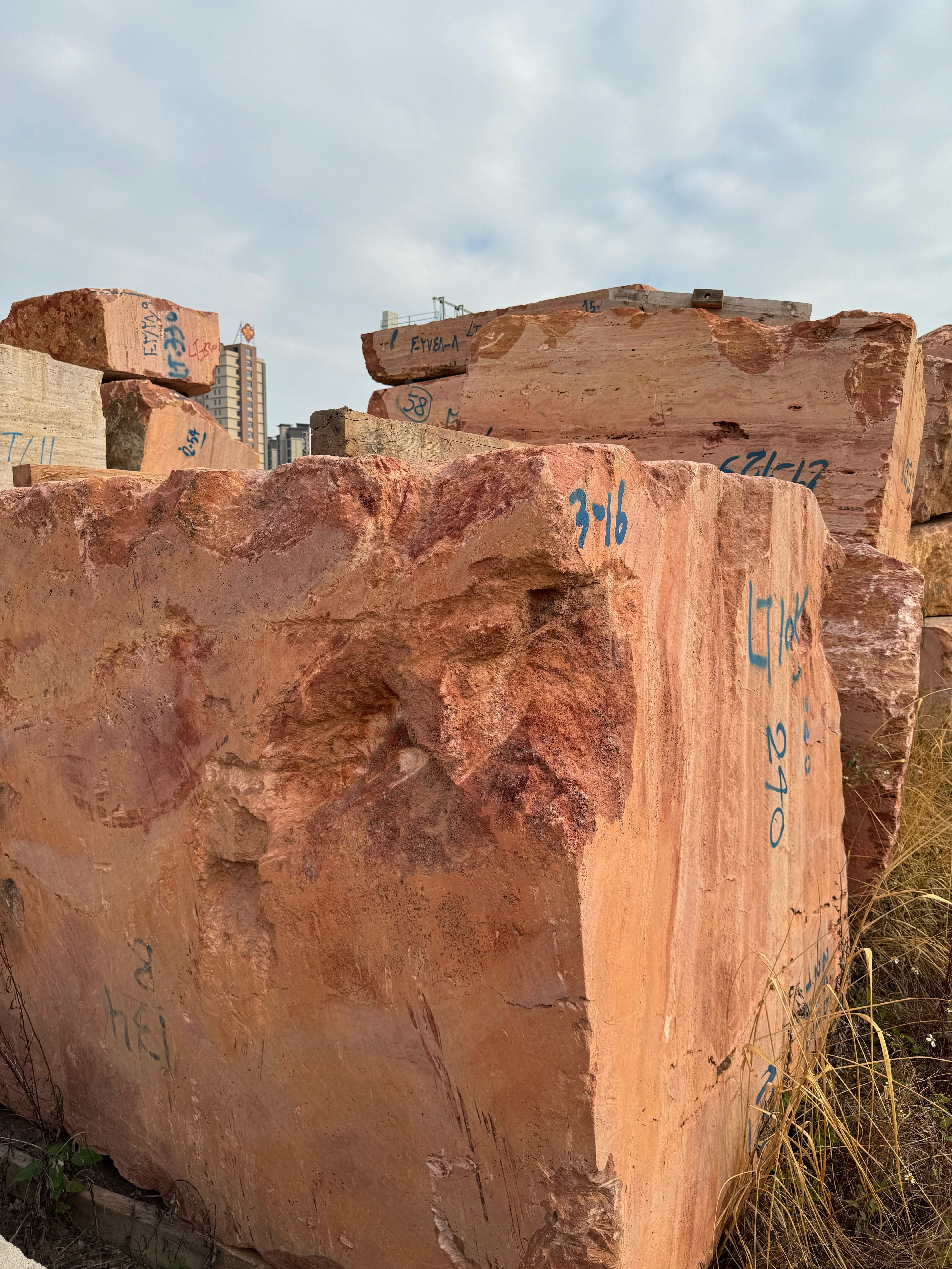 Rare Red Travertine mountain block featuring distinct horizontal banding, direct-sourced for monolithic bathtub fabrication by GustavDesign.