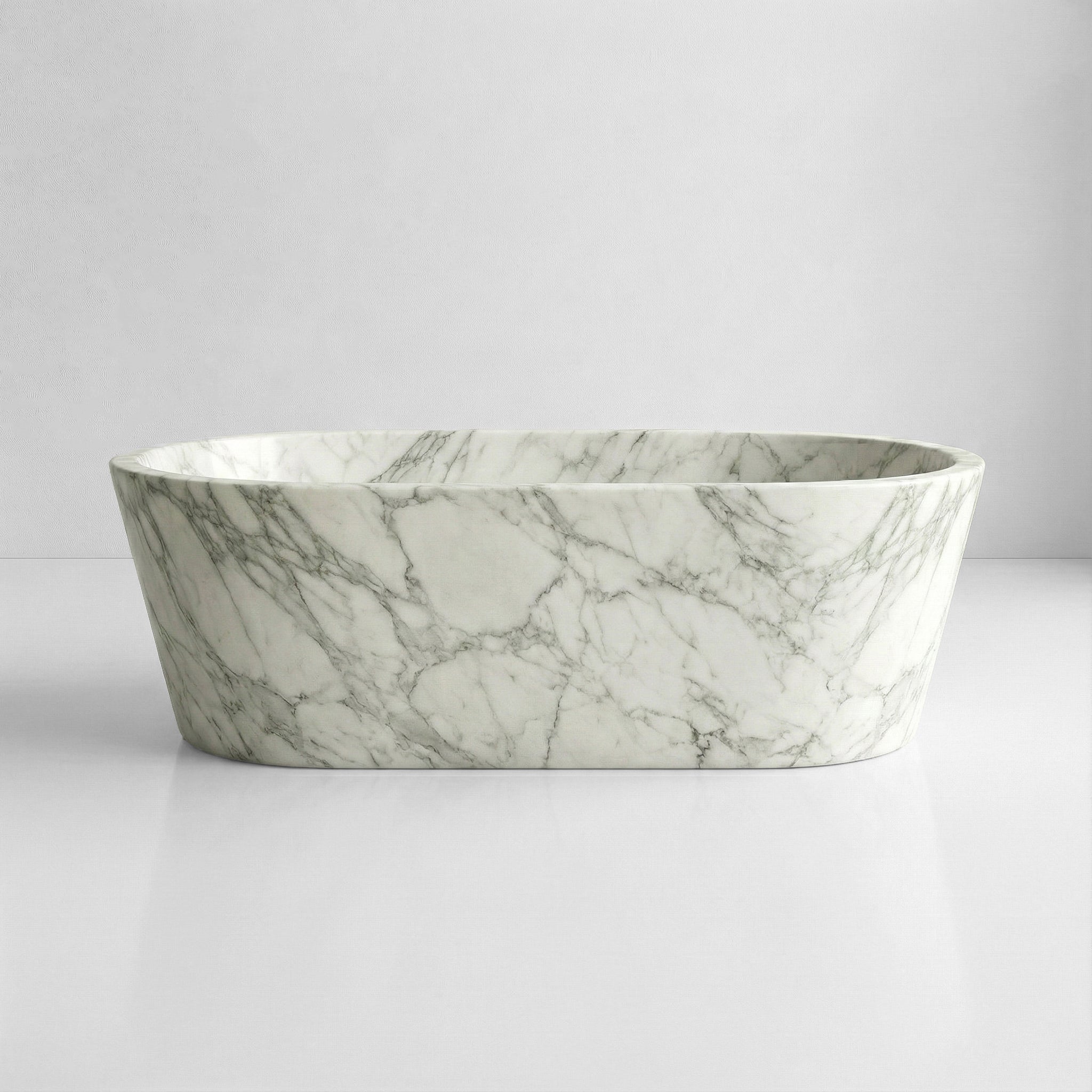 Front profile of a statement Arabescato marble bathtub featuring a polished finish and intricate, dusty grey interconnected stone patterns.
