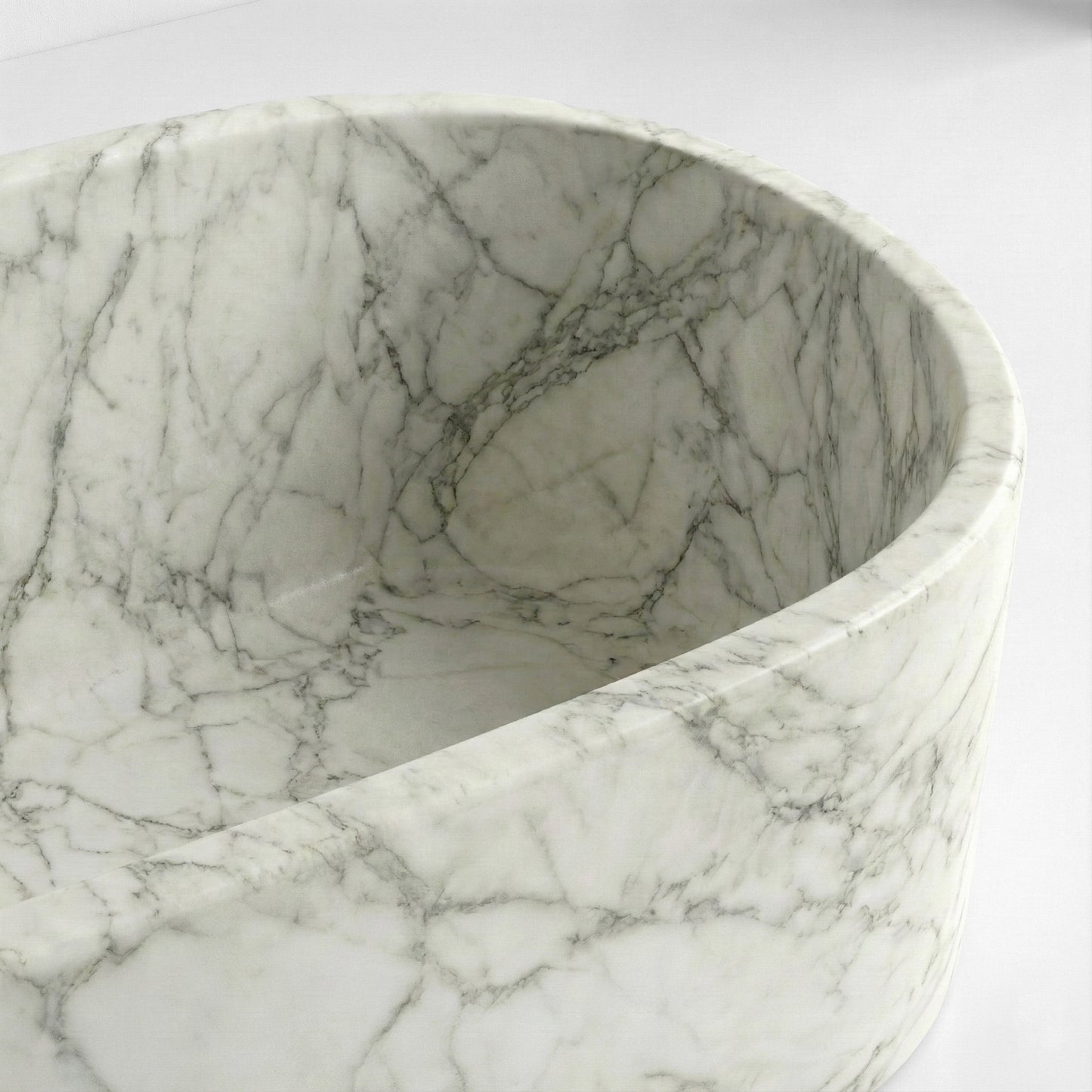 Close-up detail of an Arabescato marble bathtub rim showing the natural grey veining and polished white stone texture.