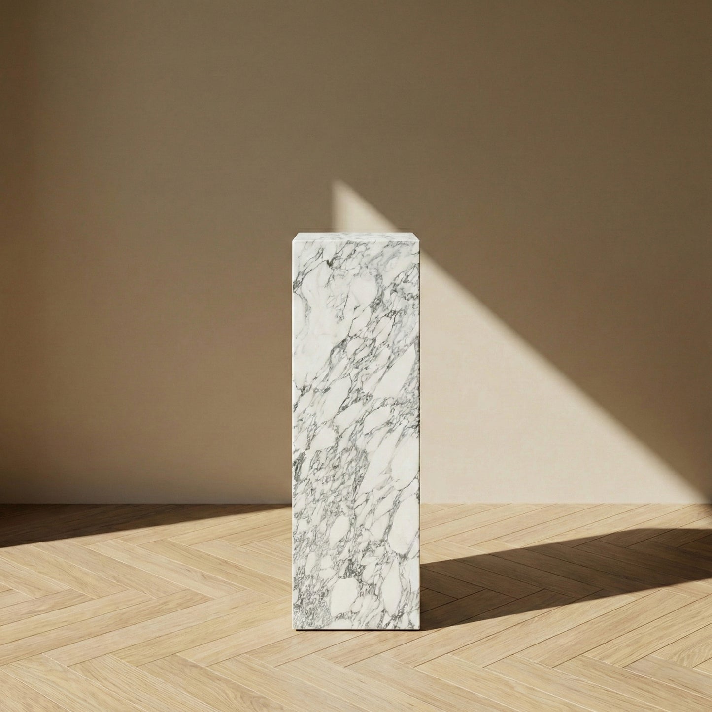 A straight-on view of an Arabescato marble pedestal stand against a neutral background, emphasizing the vertical flow of its gray-on-white natural patterns and slender proportions.
