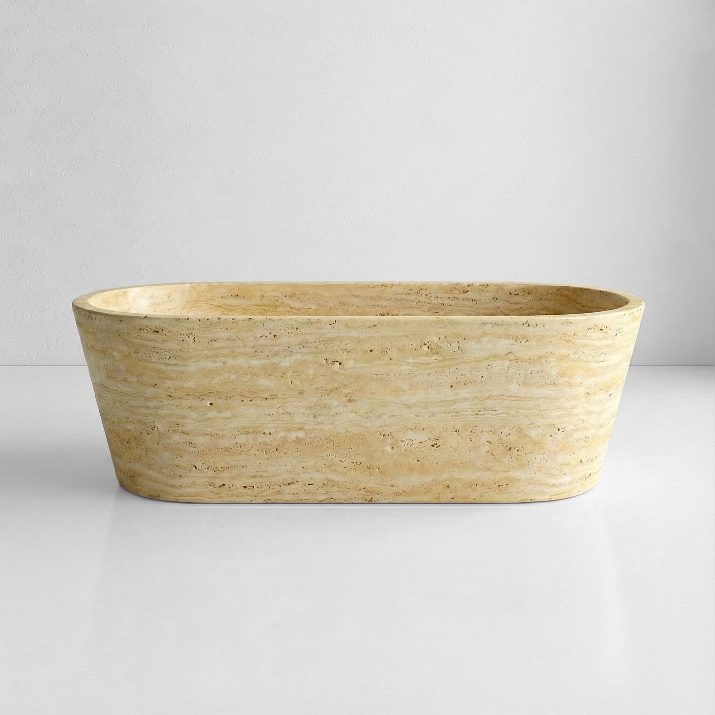 Front profile of a minimalist beige Travertine stone bathtub featuring a matte honed finish and warm, neutral earth tones.