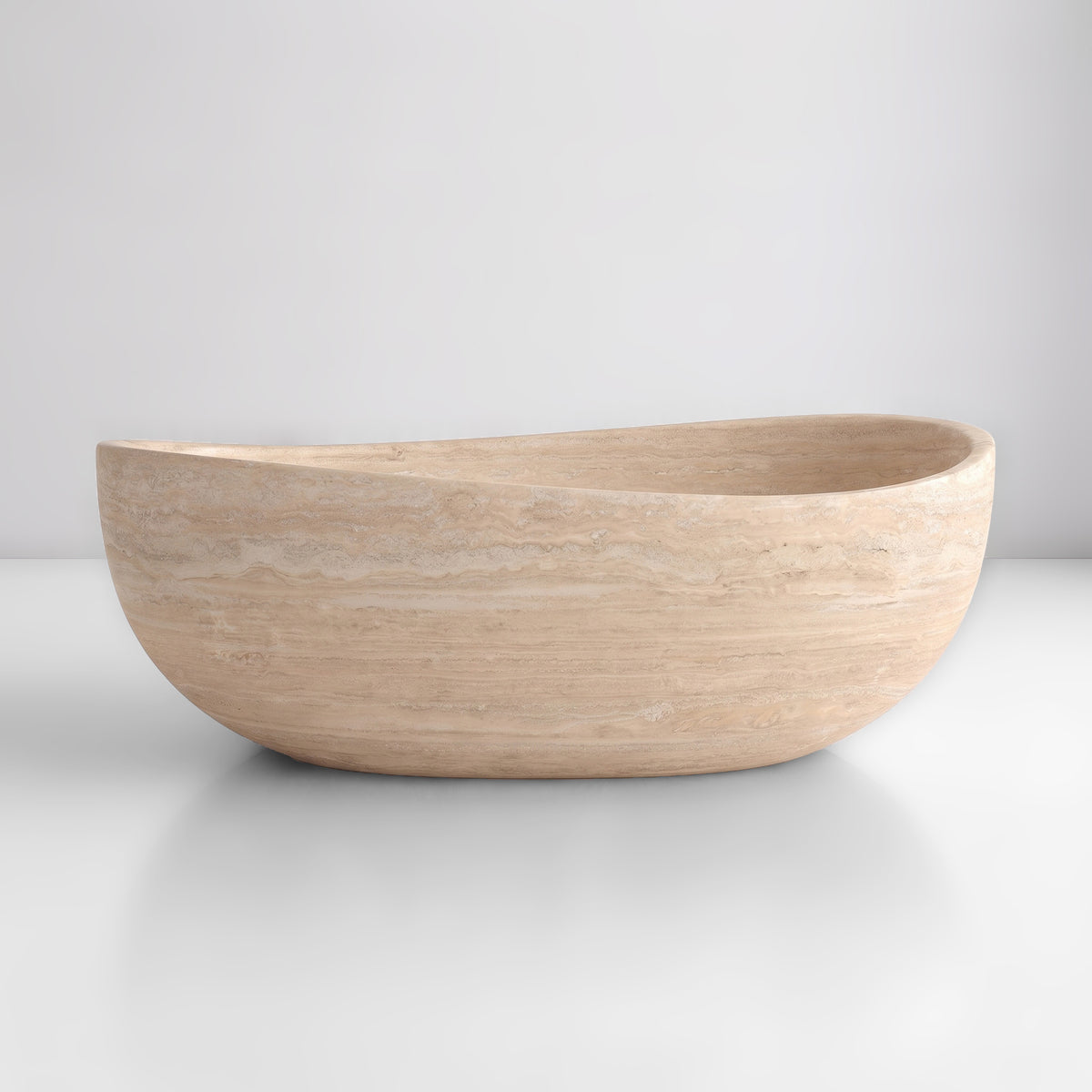 Front studio view of the freestanding Beige Travertine wave bathtub, showcasing the organic dipping rim silhouette and warm horizontal sedimentary strata across the creamy-sand stone exterior.