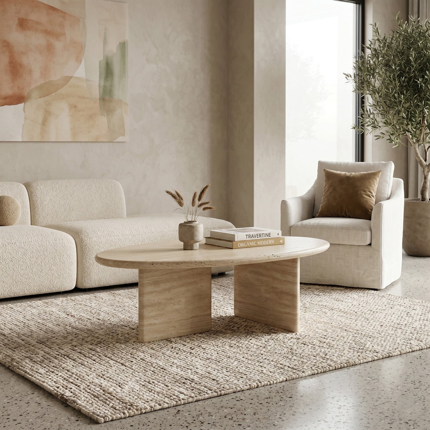 Organic modern living room featuring a bespoke beige travertine coffee table styled on a large textured rug alongside a minimalist cream sofa and armchair.