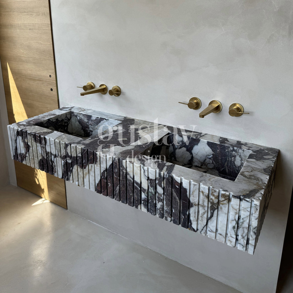 Bespoke integrated double vanity sink carved from exotic Calacatta Viola marble featuring a ribbed apron front design.