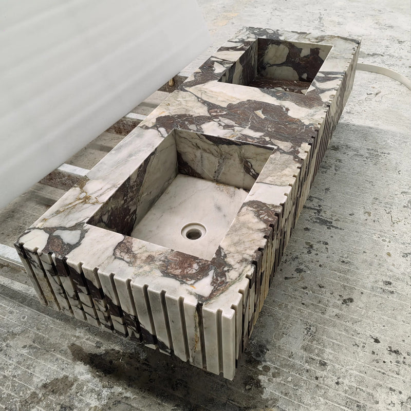 Bespoke integrated double vanity sink carved from exotic Calacatta Viola marble featuring a ribbed apron front design.