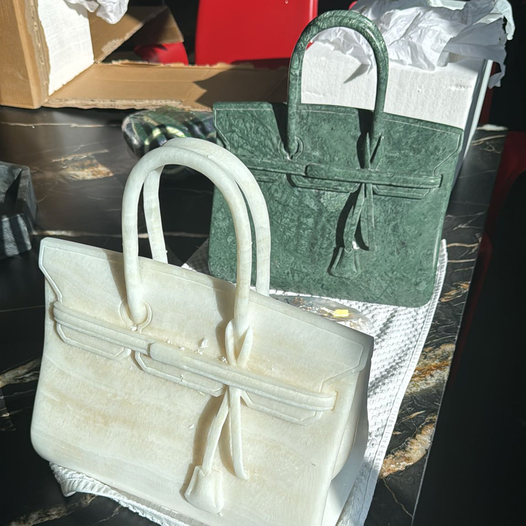 High-end custom decorative sculptures resembling luxury handbags, intricately carved from white onyx and green marble.