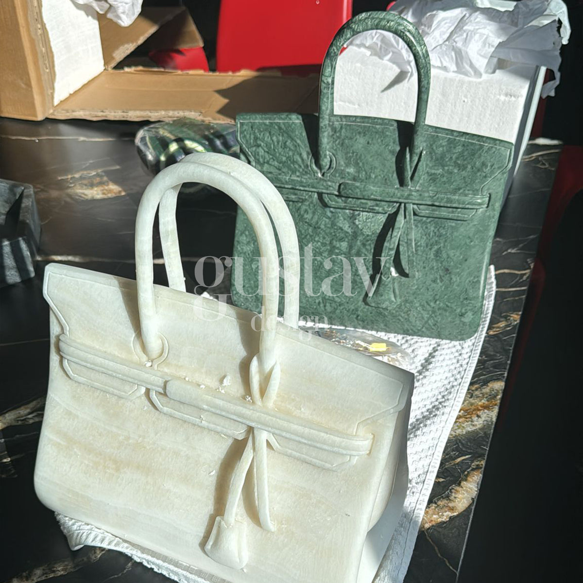 High-end custom decorative sculptures resembling luxury handbags, intricately carved from white onyx and green marble.