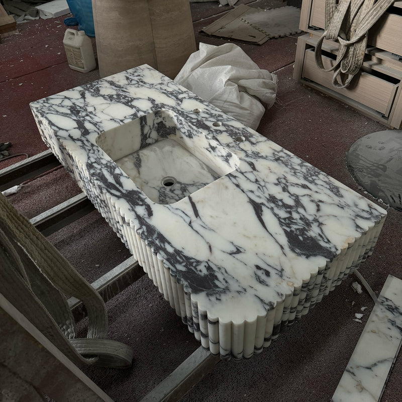 A luxury Calacatta Viola marble vanity featuring a unique fluted scalloped apron and integrated sink, handcrafted for a high-end bathroom commission by GustavDesign.