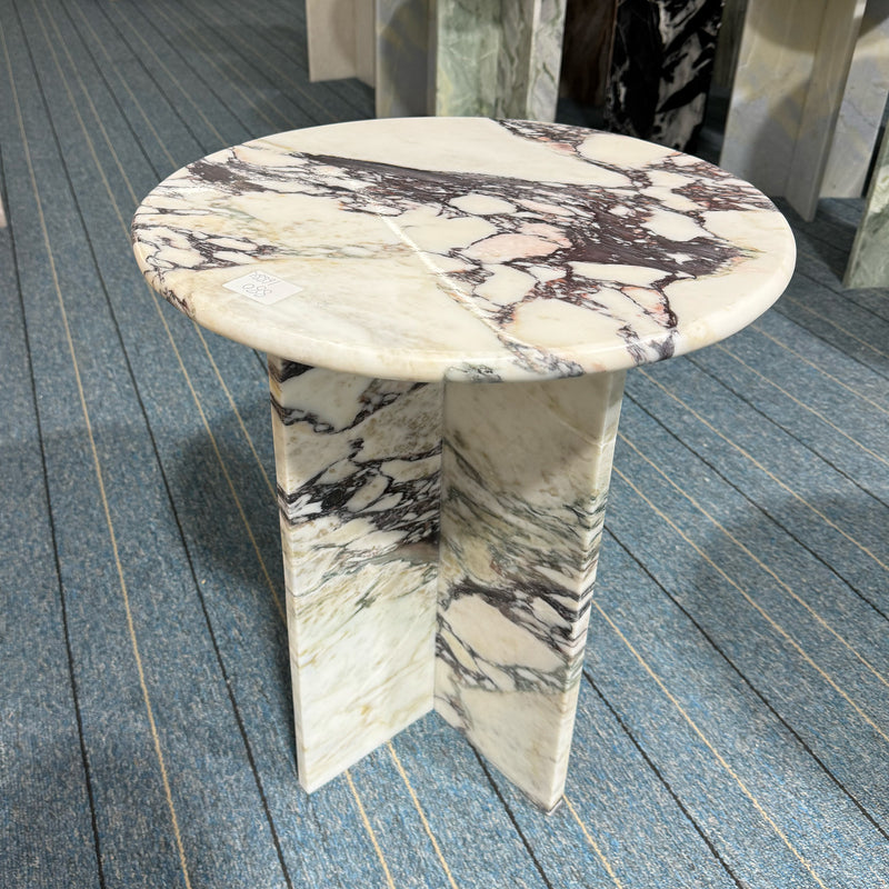 A round Calacatta Viola side table featuring a polished top and architectural cross-base, demonstrating the high-quality bespoke marble furniture craftsmanship of GustavDesign.