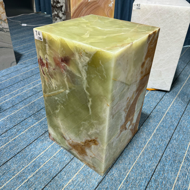 A translucent Green Onyx plinth cube with rich earthy inclusions and a polished finish, designed as a statement furniture piece for luxury interiors by GustavDesign.