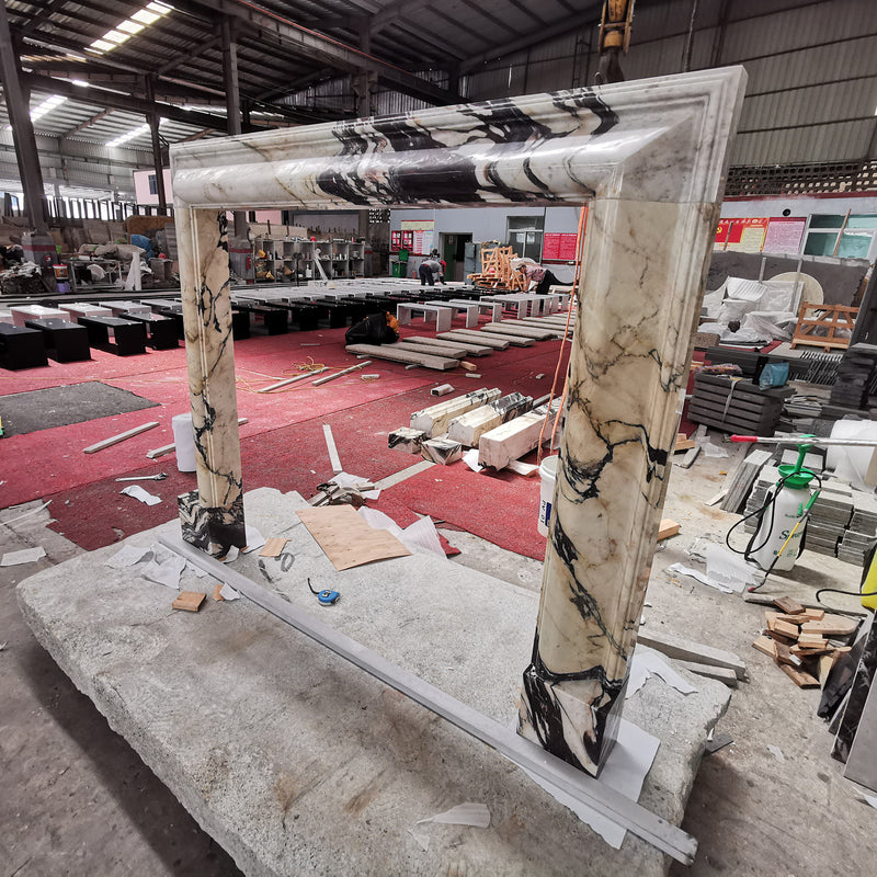 A custom Calacatta Viola marble fireplace mantle frame during factory assembly, showcasing the bold natural veining and precision mitered edges of GustavDesign's bespoke architectural stonework.