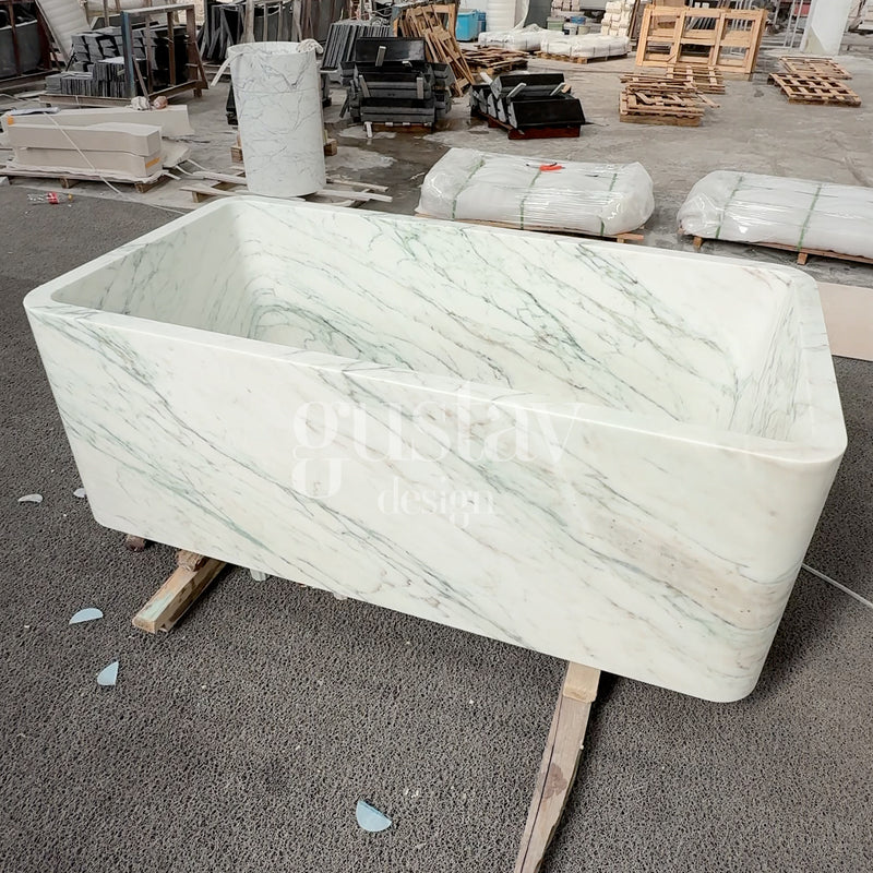Freestanding rectangular white marble bathtub with elegant green veining, custom-carved luxury stone soaking tub by Gustav Design.