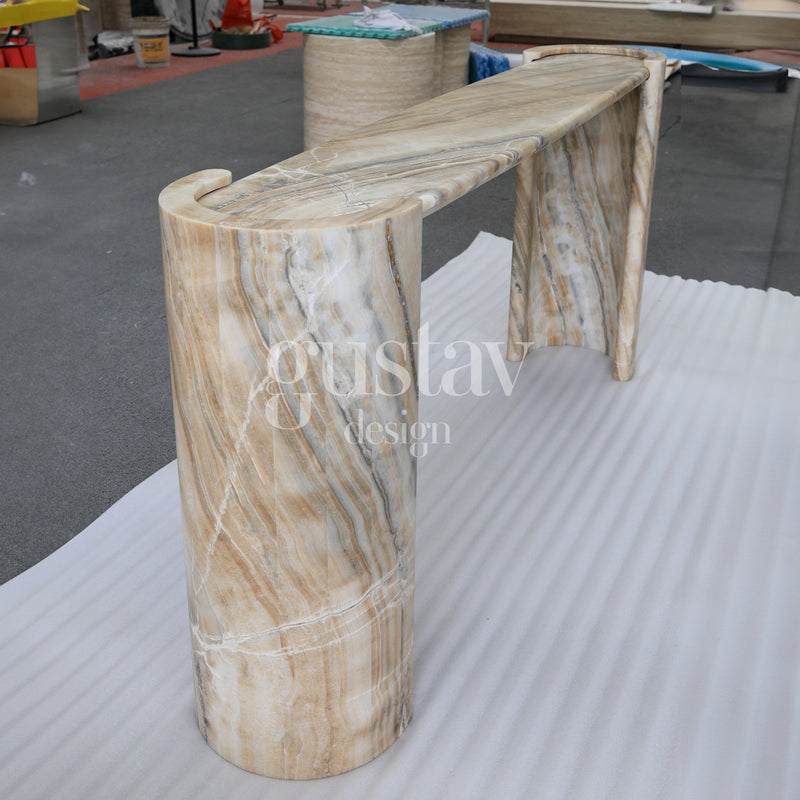 Elegant curved onyx console table with dramatic tan, grey, and cream natural veining, luxury stone entryway furniture by Gustav Design.