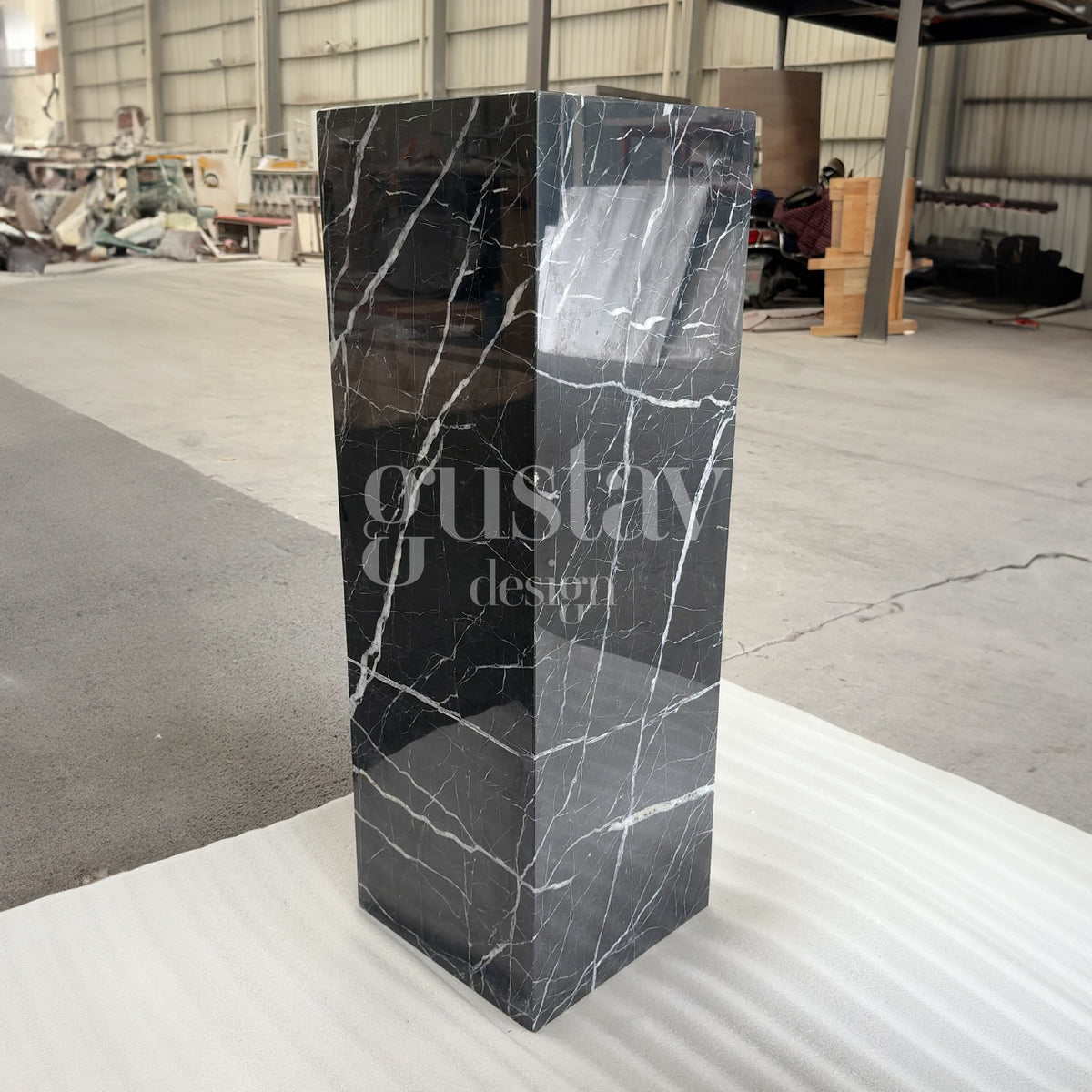 Polished Nero Marquina marble pedestal plinth with striking white veining, luxury stone display stand by Gustav Design.