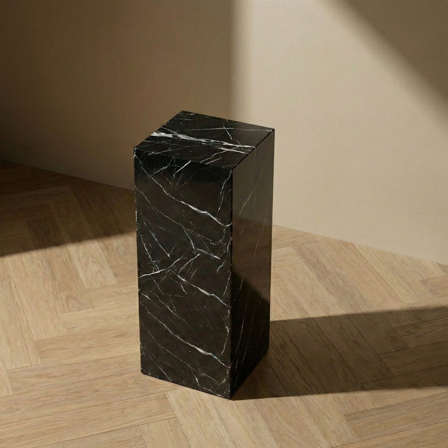 Rectangular Nero Marquina marble plinth stand featuring natural white veining on light oak herringbone flooring.