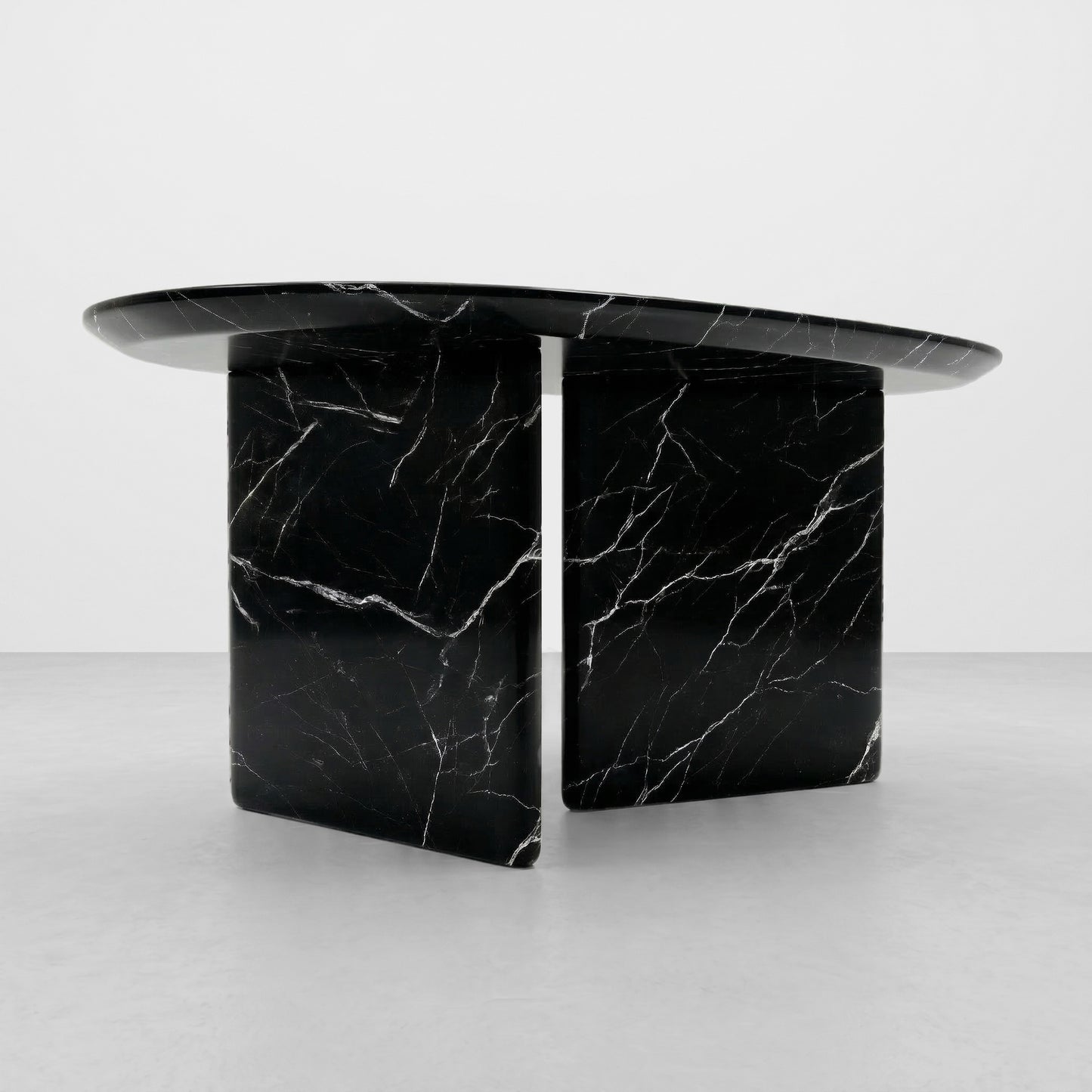 Close-up detail of the striking white lightning veining on a polished Black Marquina marble coffee table, highlighting the natural stone texture and smooth radiused edge.