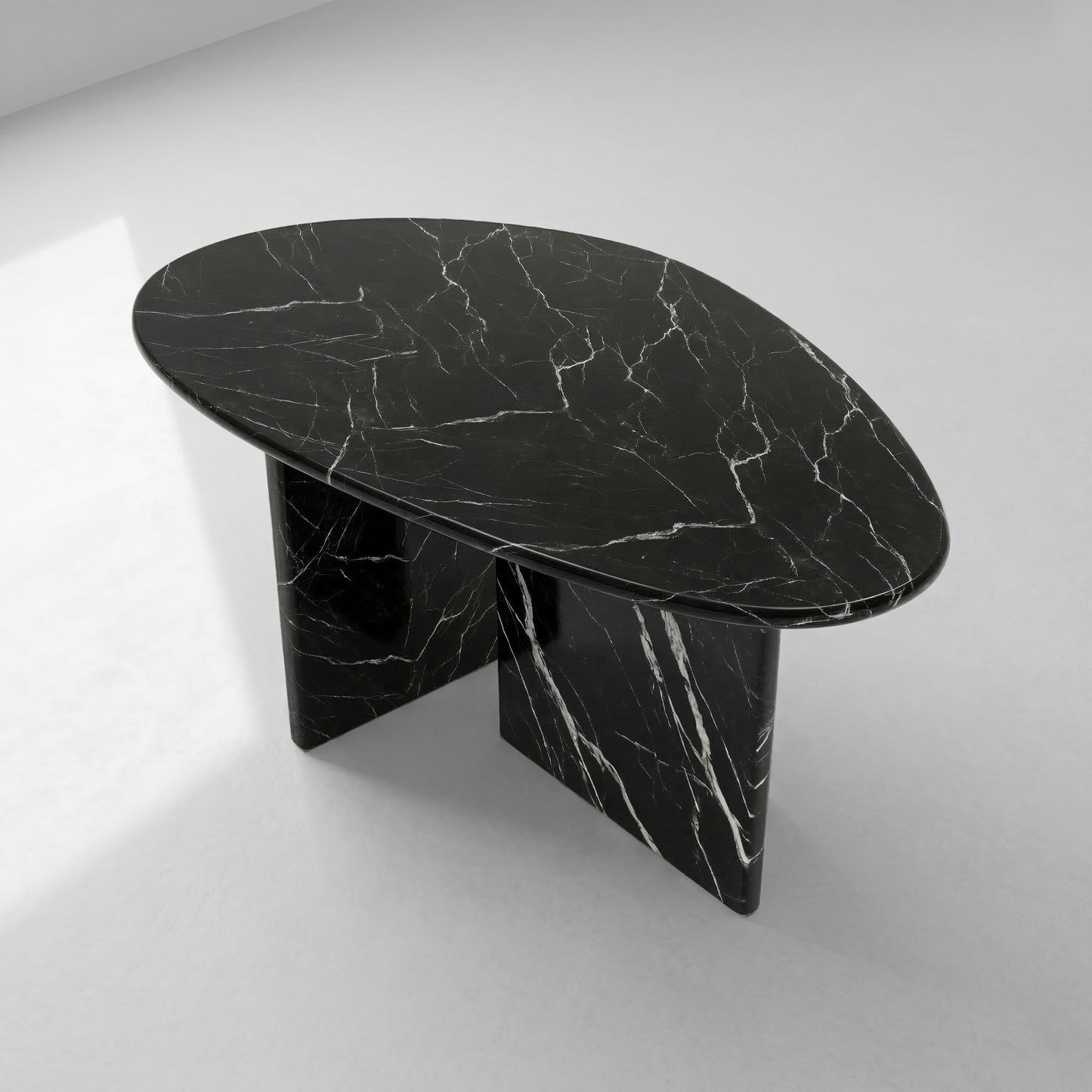 High-angle top view of a pebble-shaped Black Marquina marble coffee table showcasing its organic silhouette and sophisticated natural white veining.