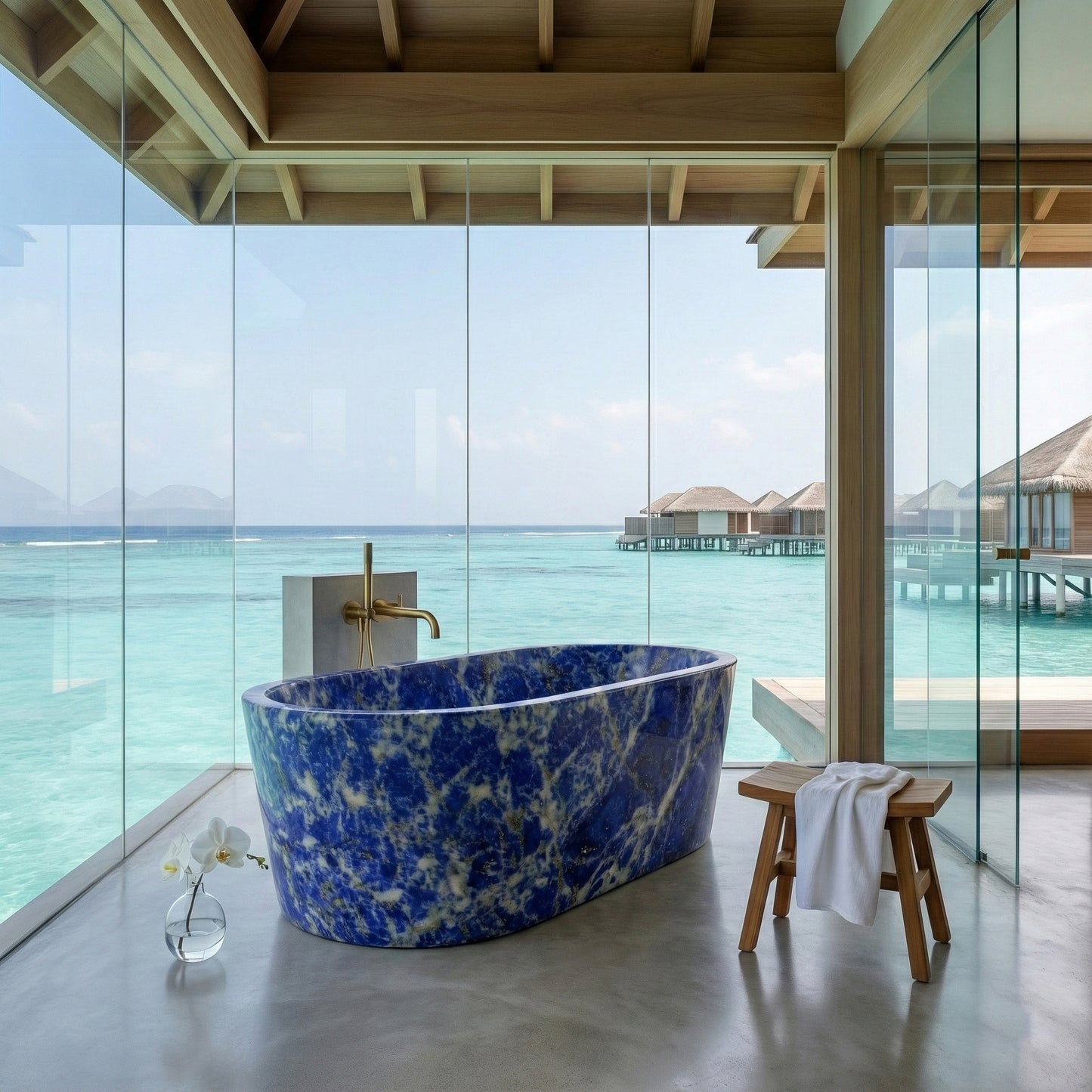Luxury oceanfront bathroom suite featuring a Blue Sodalite semi-precious stone bathtub, floor-to-ceiling glass walls with turquoise water views, and natural wood accents.