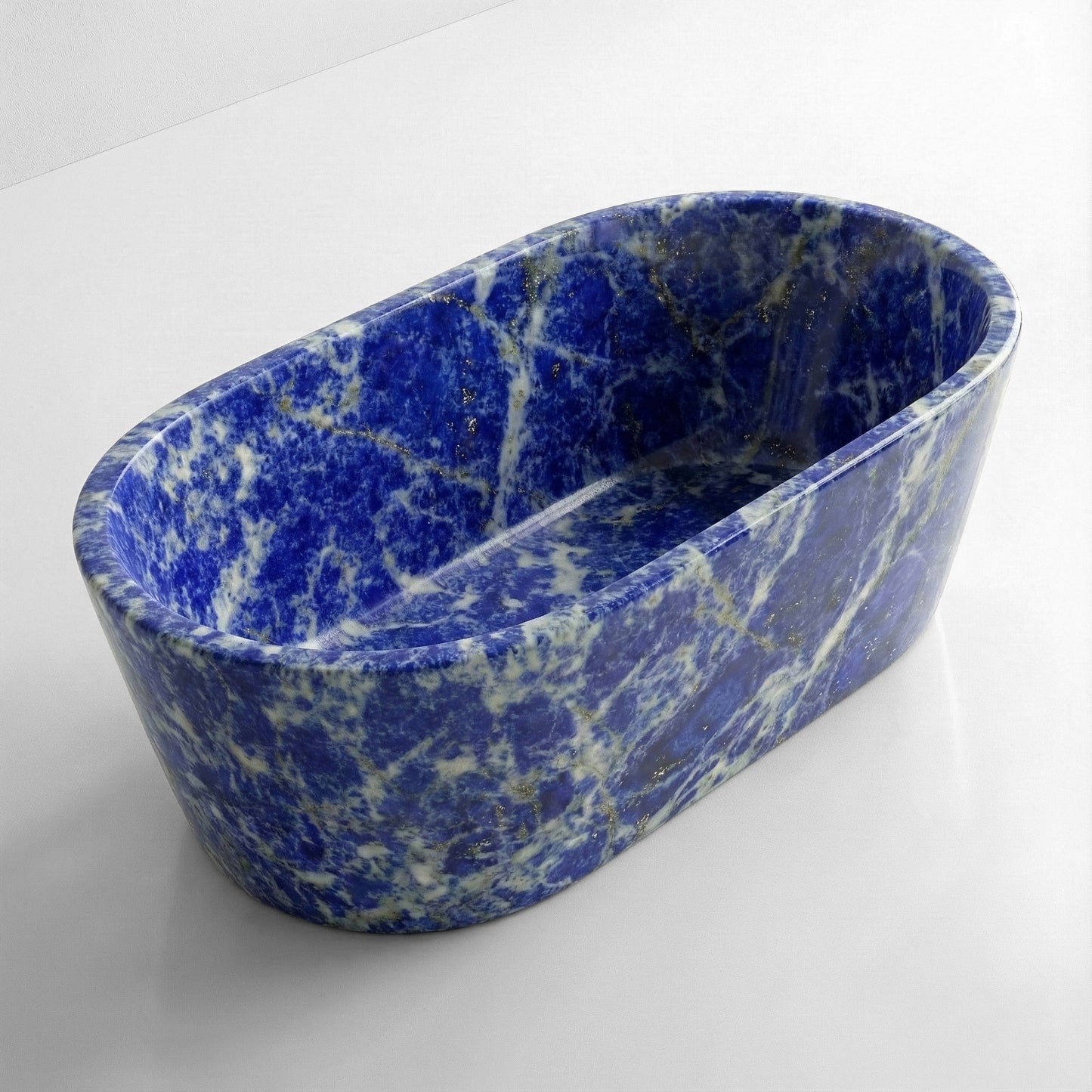 High-angle view of a freestanding oval Blue Sodalite bathtub, displaying a polished deep blue surface with intricate white calcite veining and gold pyrite flecks.