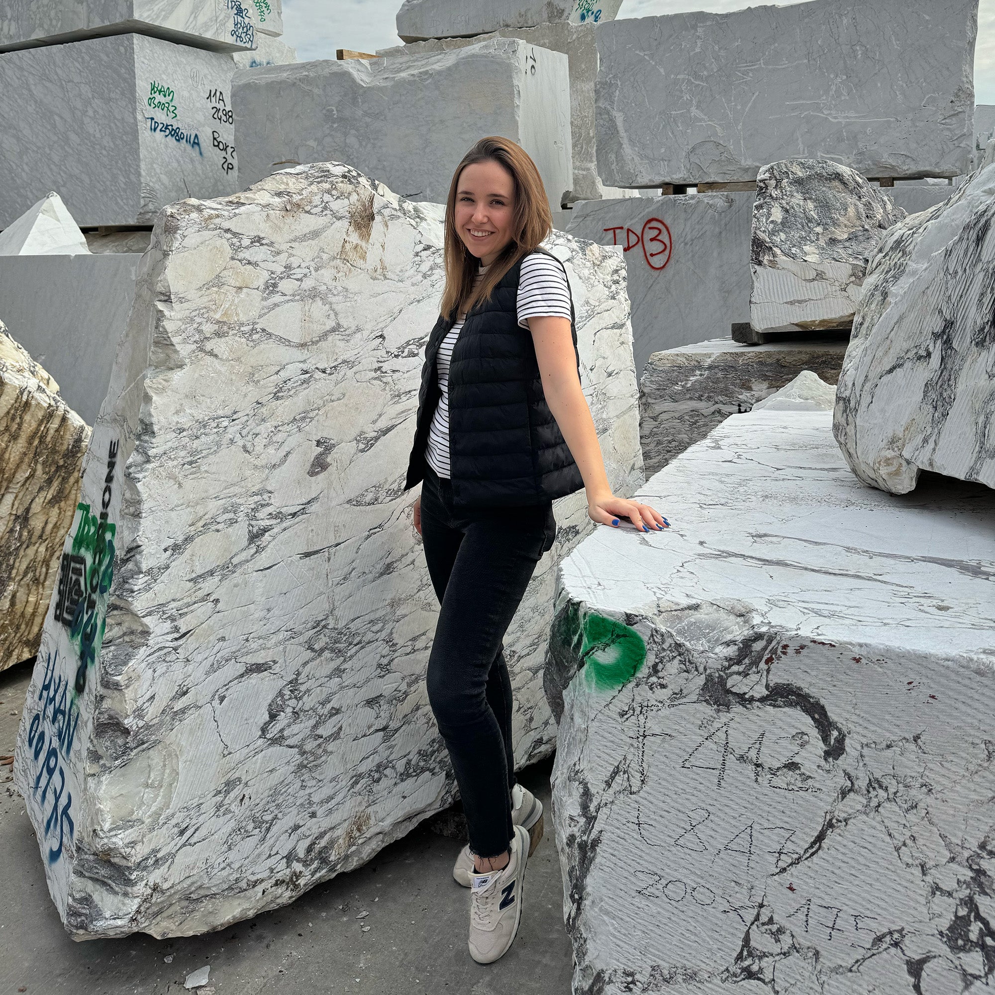 CAD Architect Julia of GustavDesign selecting premium raw marble blocks at the stone yard for a high-end bespoke architectural commission.