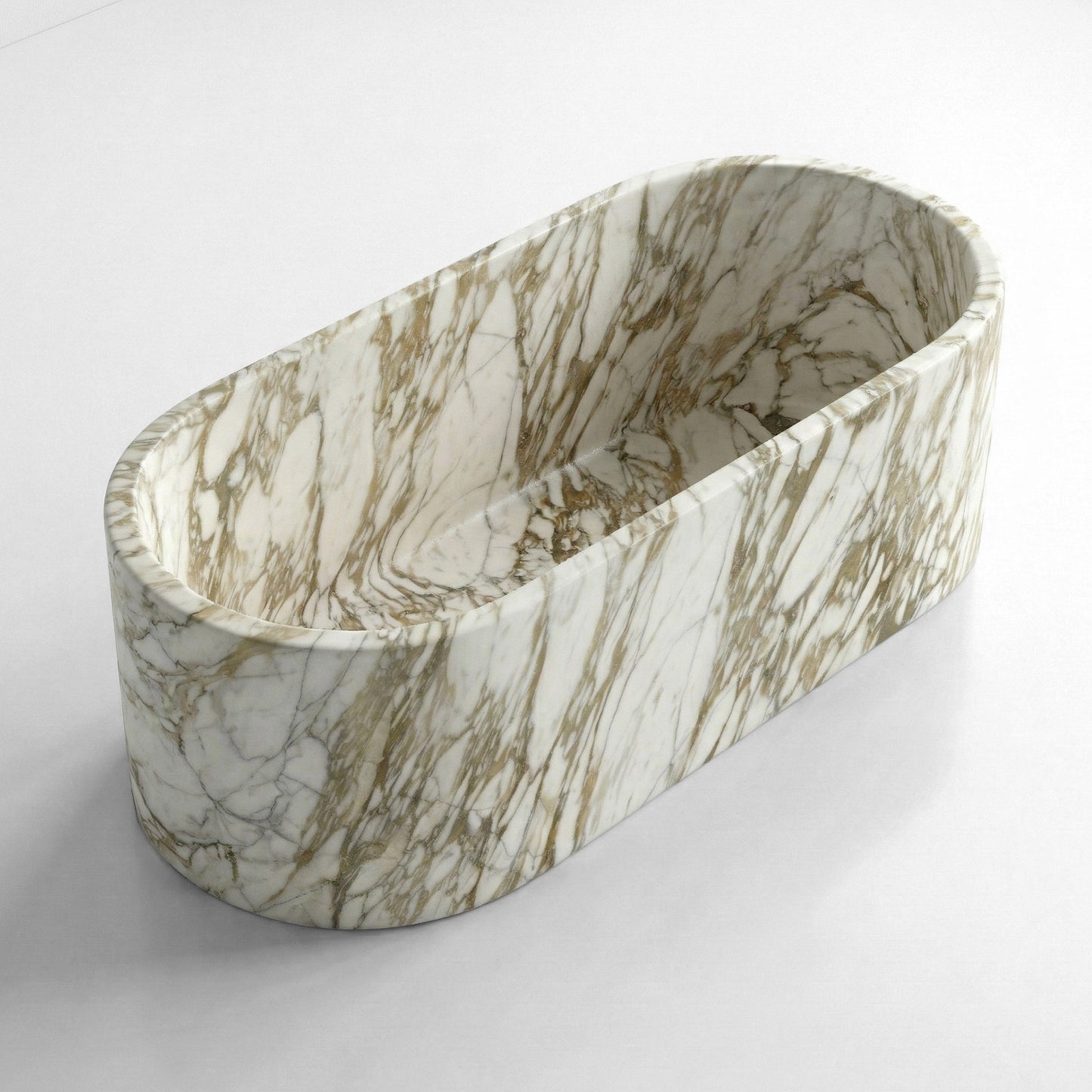 An angled top-down view of a deep, straight-sided oval Calacatta Gold marble bathtub, highlighting the bold natural patterns of the stone.