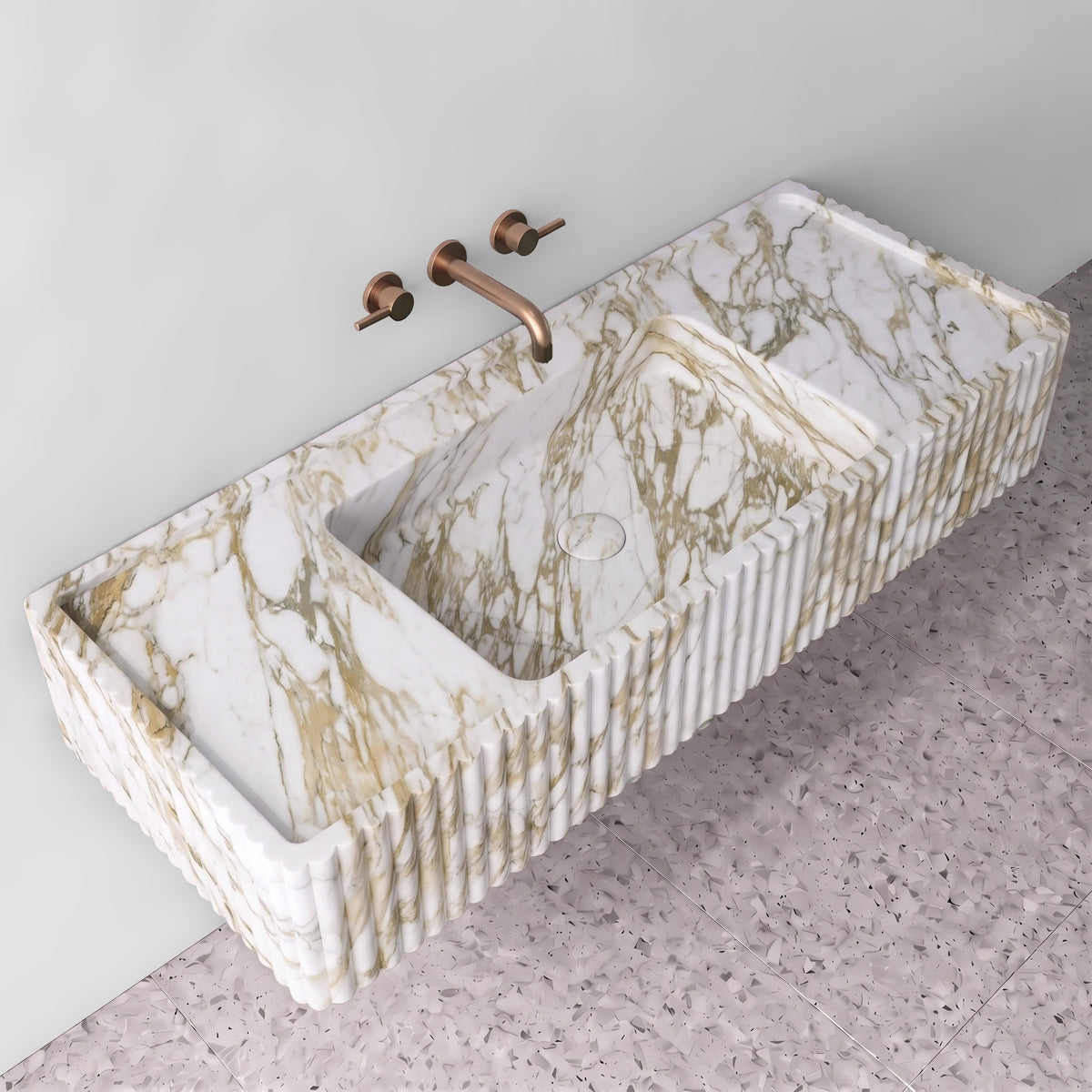 Elevated angle of the Calacatta Gold fluted monolith sink showing the integrated trough basin, matching stone drain cover, raised perimeter edge, and side counter deck.