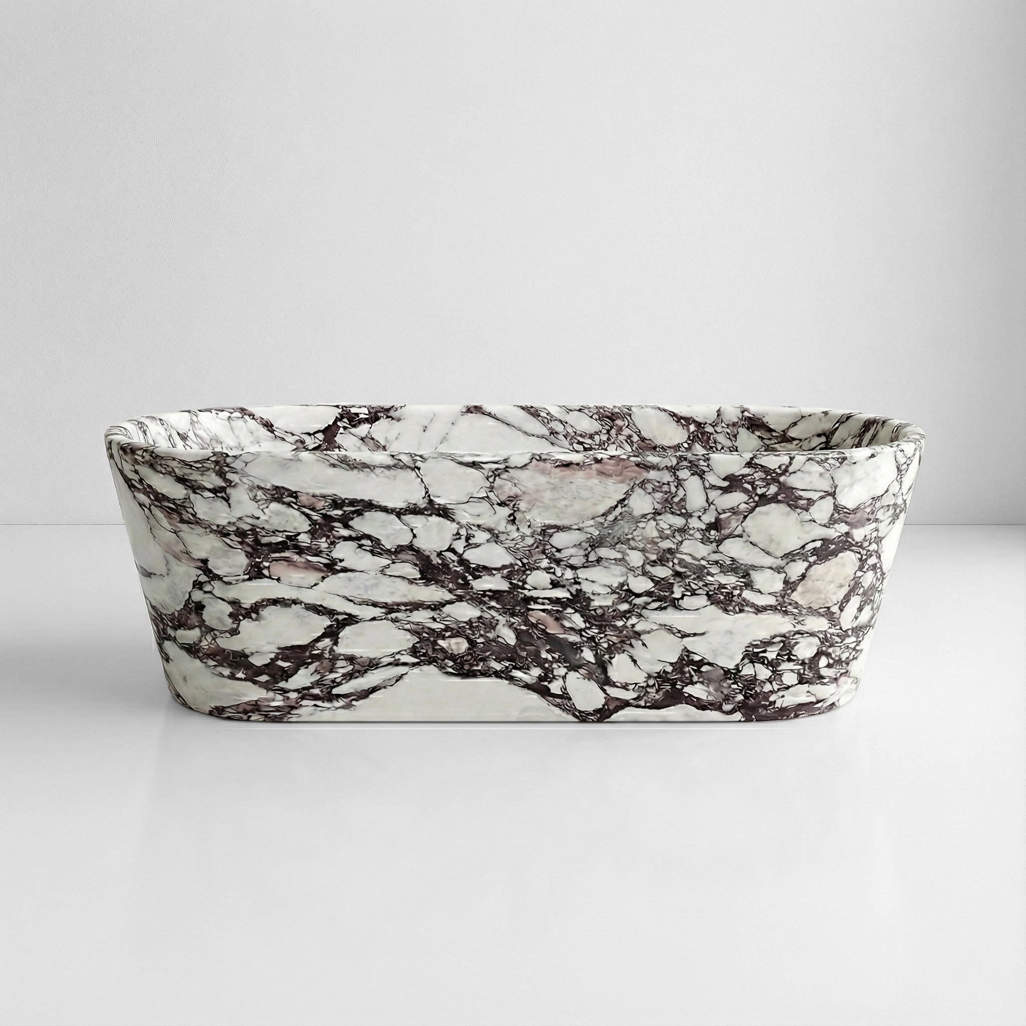 Front profile view of a luxury Calacatta Viola marble soaking tub featuring dramatic purple and white natural stone veining against a minimal background.