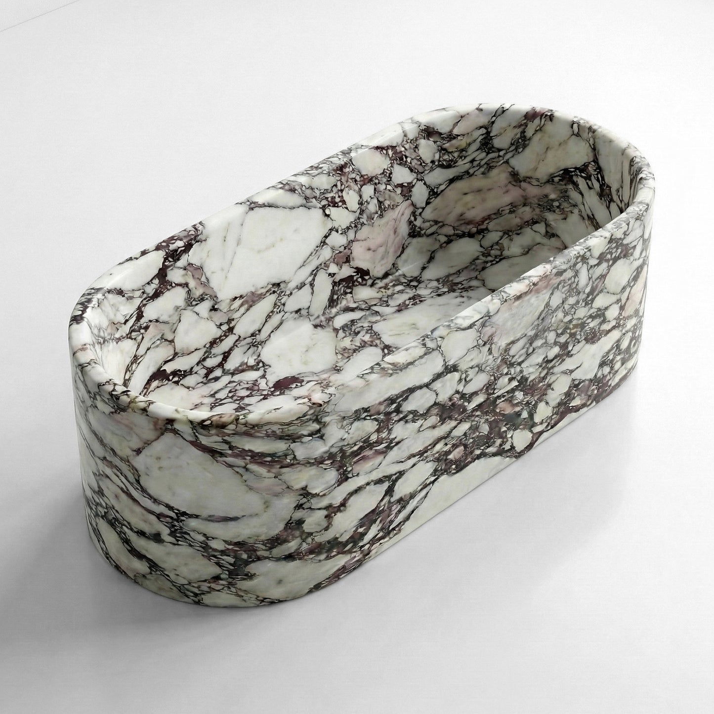 Angled isometric view of a deep soaking Calacatta Viola natural stone bathtub showing interior depth and seamless exterior.