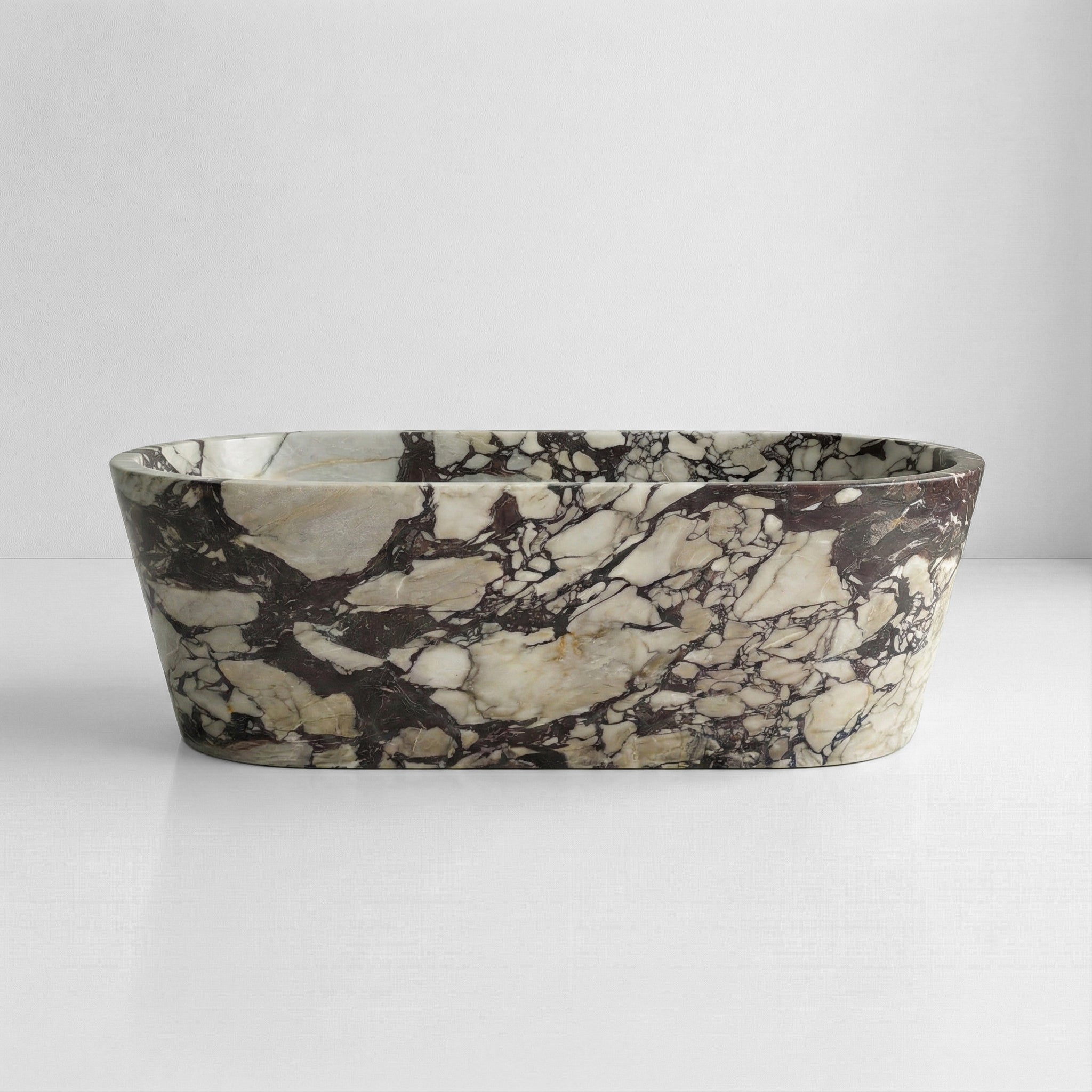 Front profile of a statement Calacatta Viola Extra marble bathtub, showcasing intense burgundy and violet veining on a creamy white background.