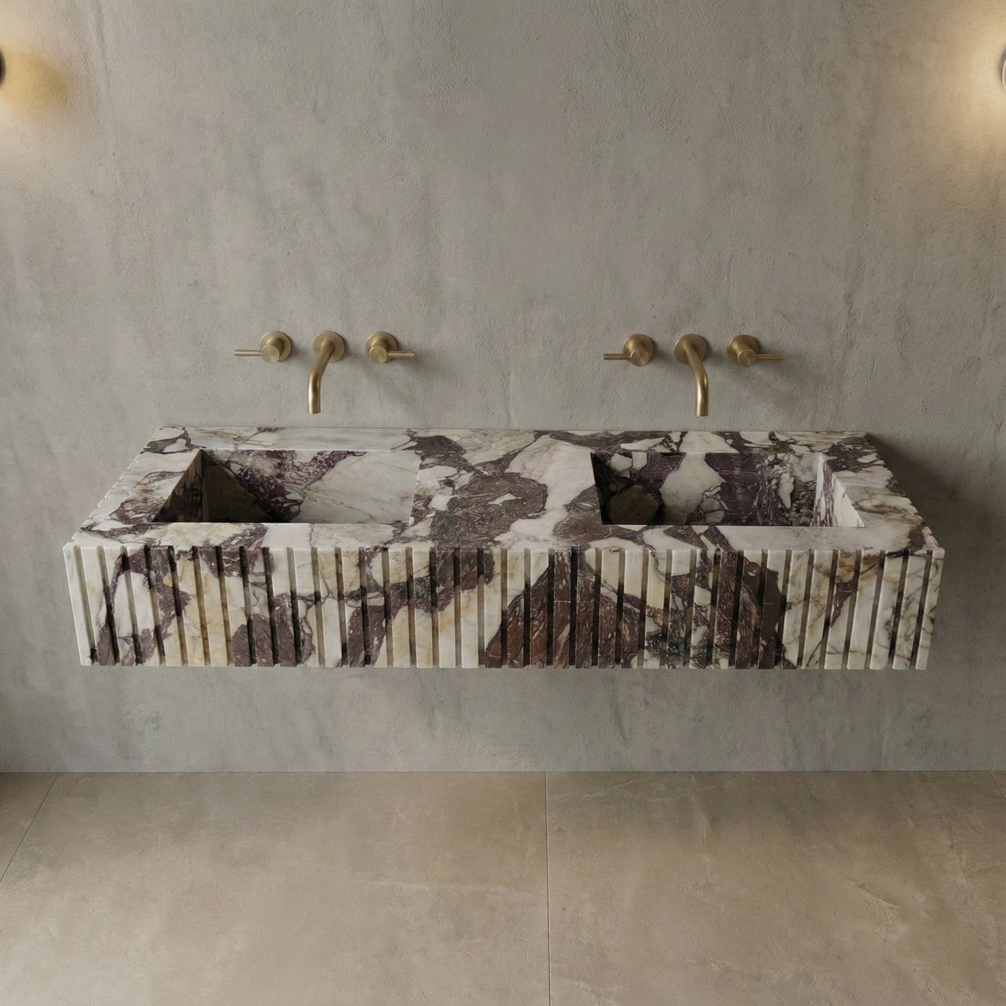 Front profile of a statement Calacatta Viola Extra marble double vanity, featuring a custom fluted stone apron and dramatic burgundy veining.