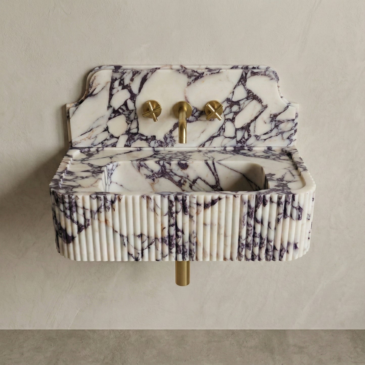 Front profile of a wall-mounted Calacatta Viola washbasin with a decorative high backsplash, vertical ribbed texture, and bold burgundy natural veining.