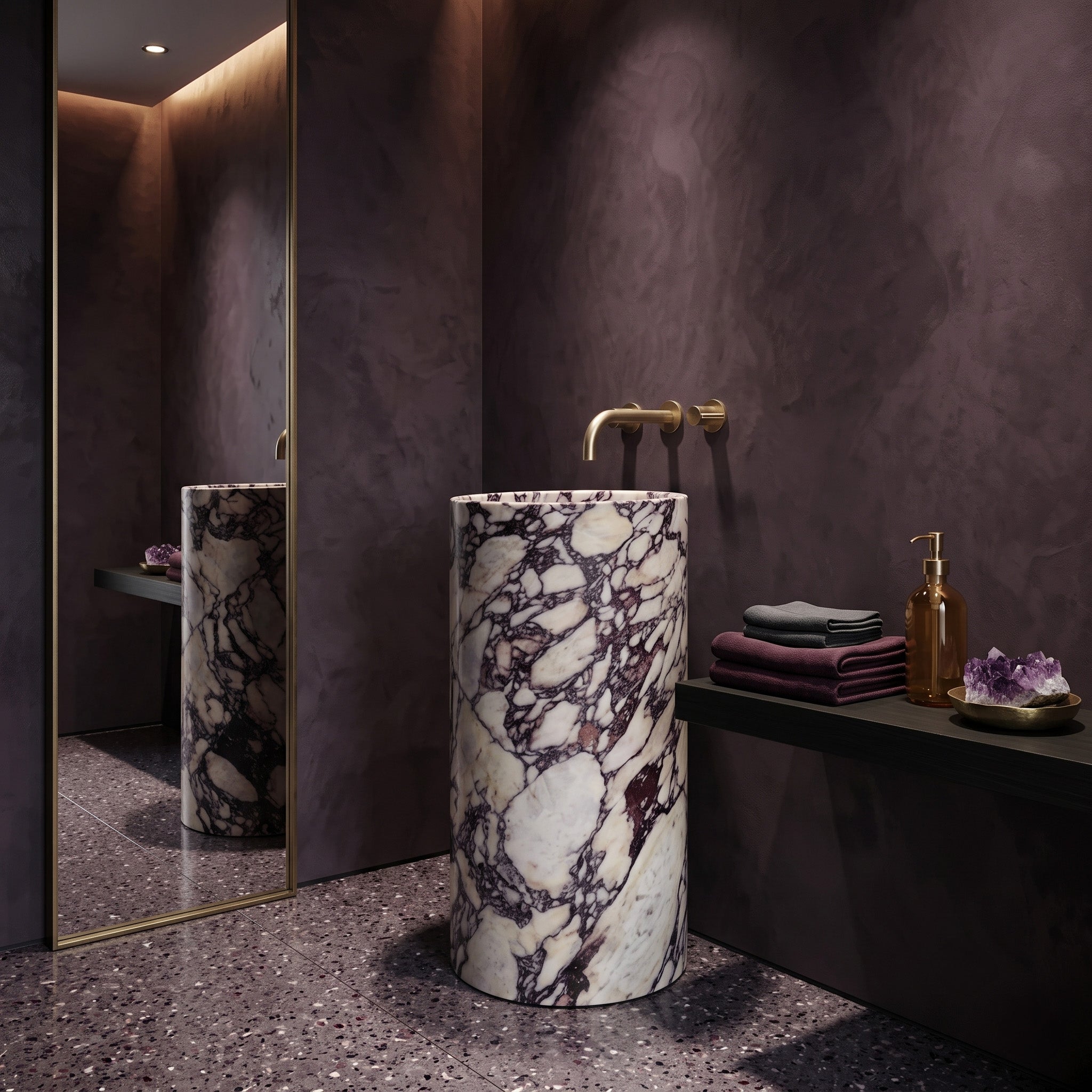 Freestanding Calacatta Viola marble pedestal sink in a moody plum plaster bathroom featuring terrazzo flooring, full-length mirror, and gold wall-mount tapware.