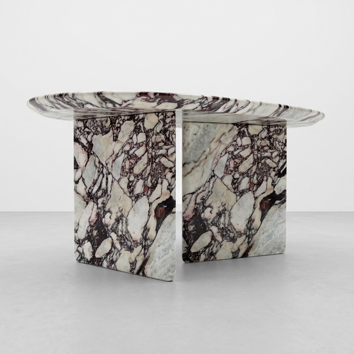 Detailed close-up of the dramatic burgundy and purple veining of a Calacatta Viola marble table, highlighting the natural stone brecciation and polished finish.