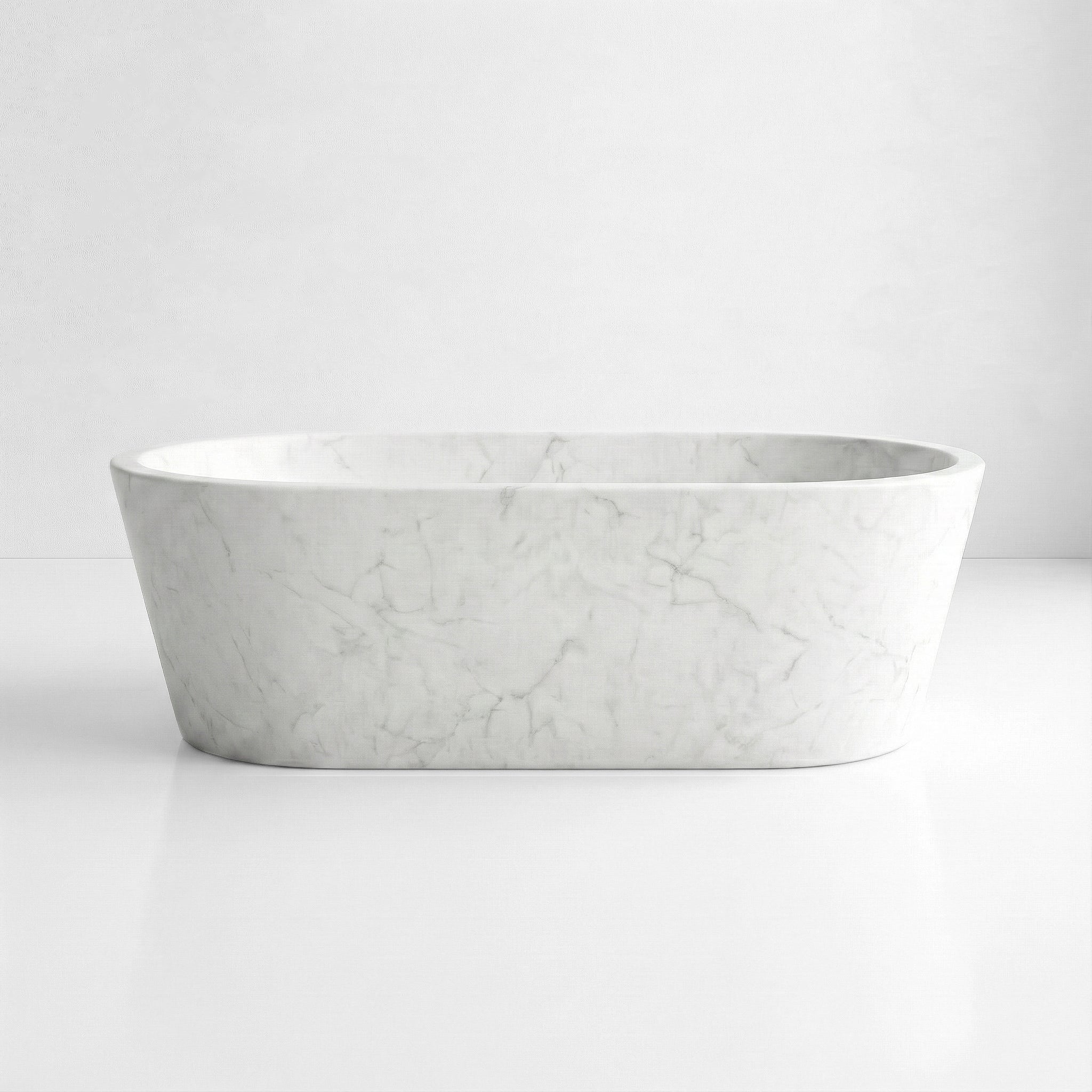 Front profile of a minimalist White Carrara marble bathtub, featuring a freestanding oval shape and subtle soft grey natural stone veining.