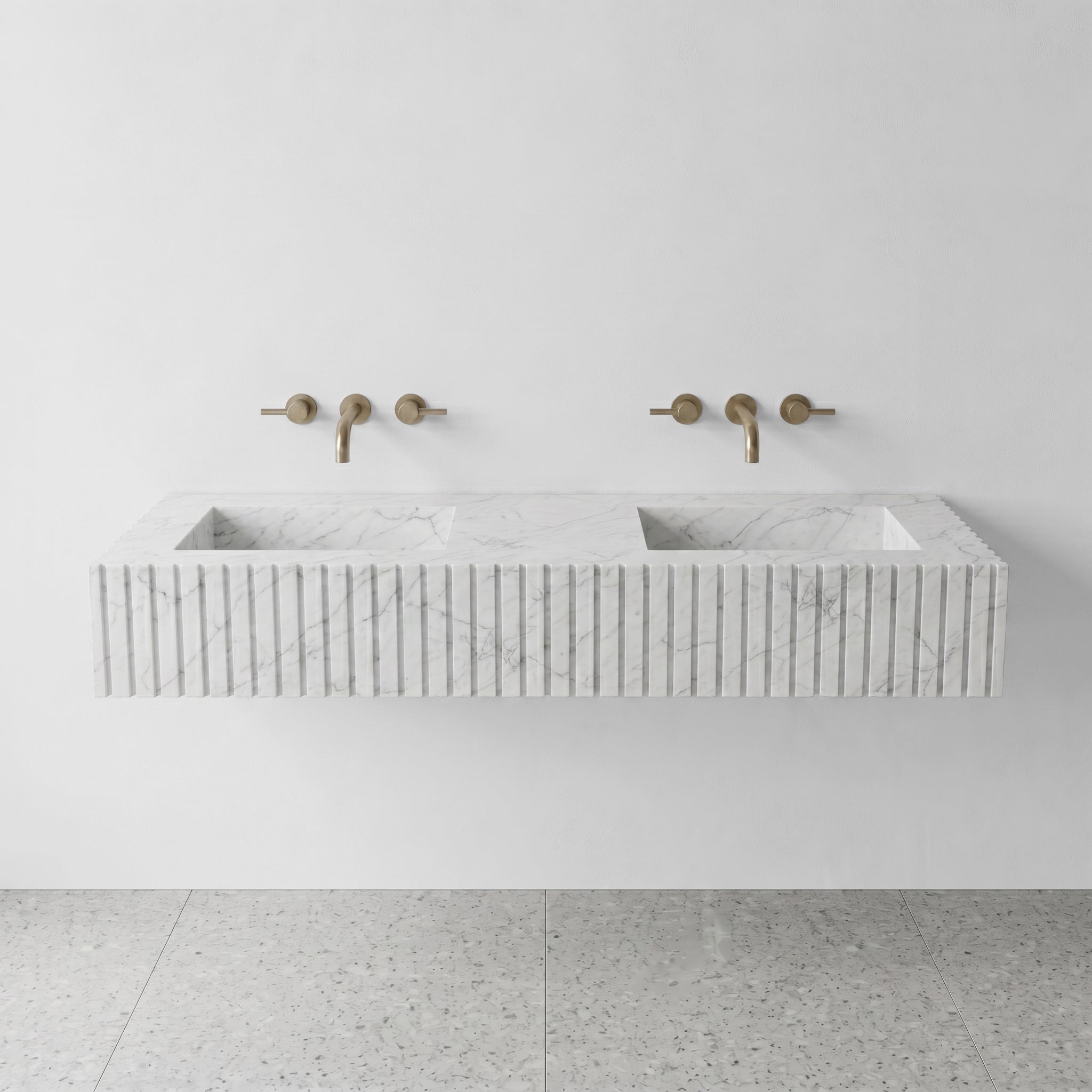 Front profile of a floating double vanity made from honed Carrara marble, featuring a custom ribbed stone apron and dual integrated basins.