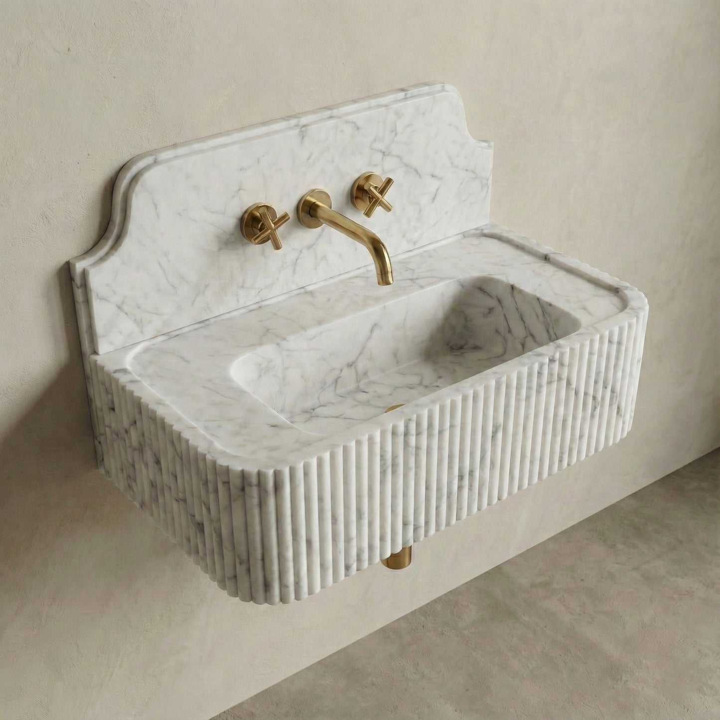 High-angle side view of a vintage-style Carrara marble sink, showcasing the curved stone backsplash, fluted apron, and brass cross-handle faucet.