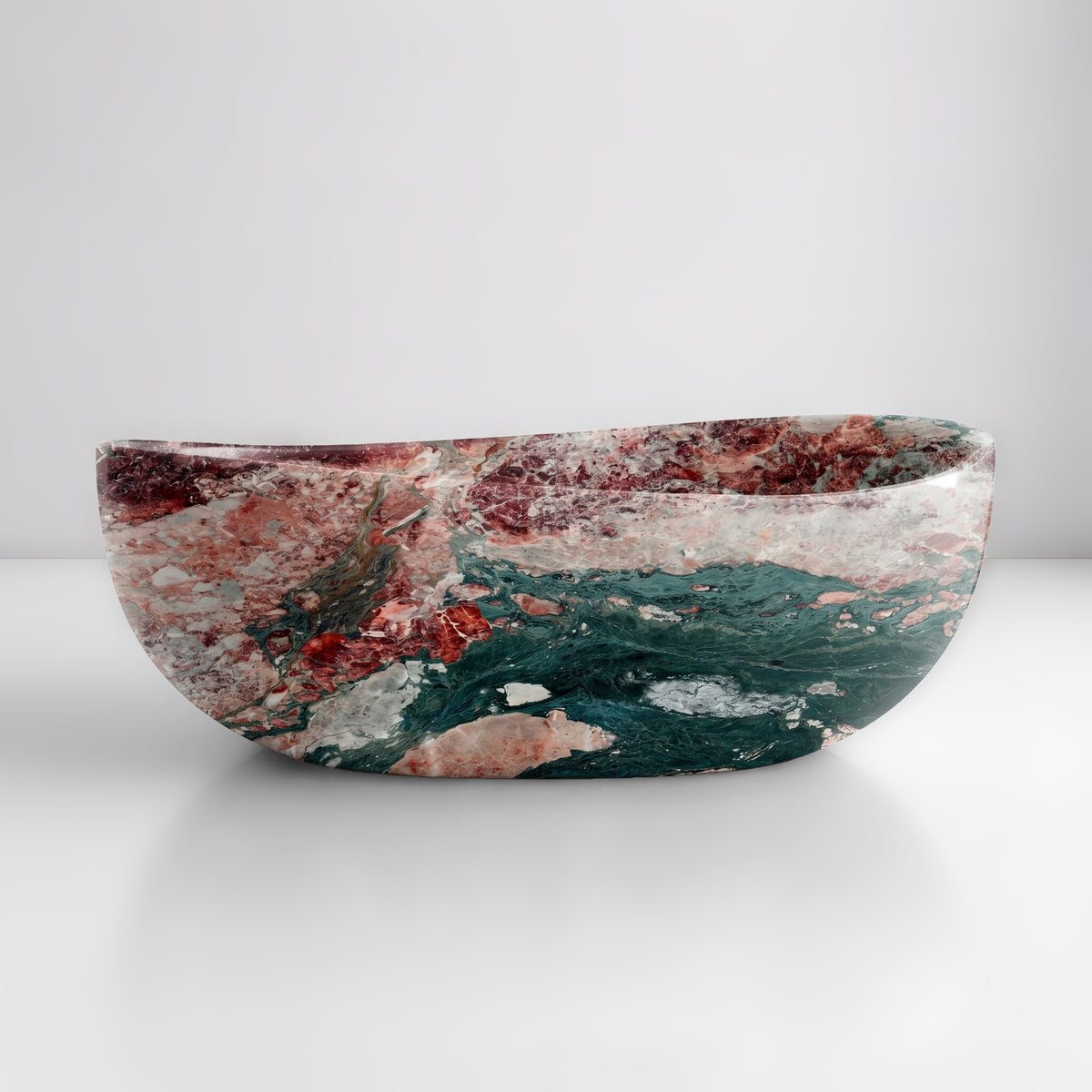 Front studio view of the freestanding Four Seasons marble wave bathtub, showcasing the organic dipping rim silhouette and dramatic swirl of forest green, dusty rose, burgundy, and white breccia across the polished stone exterior.
