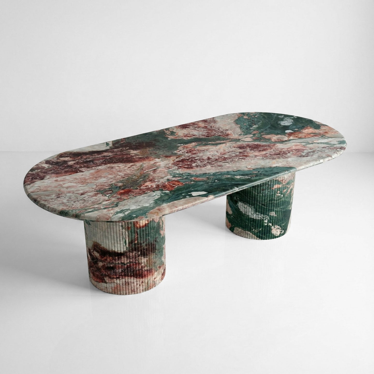 High-angle view of a statement Four Seasons marble dining table with a large oval top, displaying vibrant multi-colored brecciated stone veining.