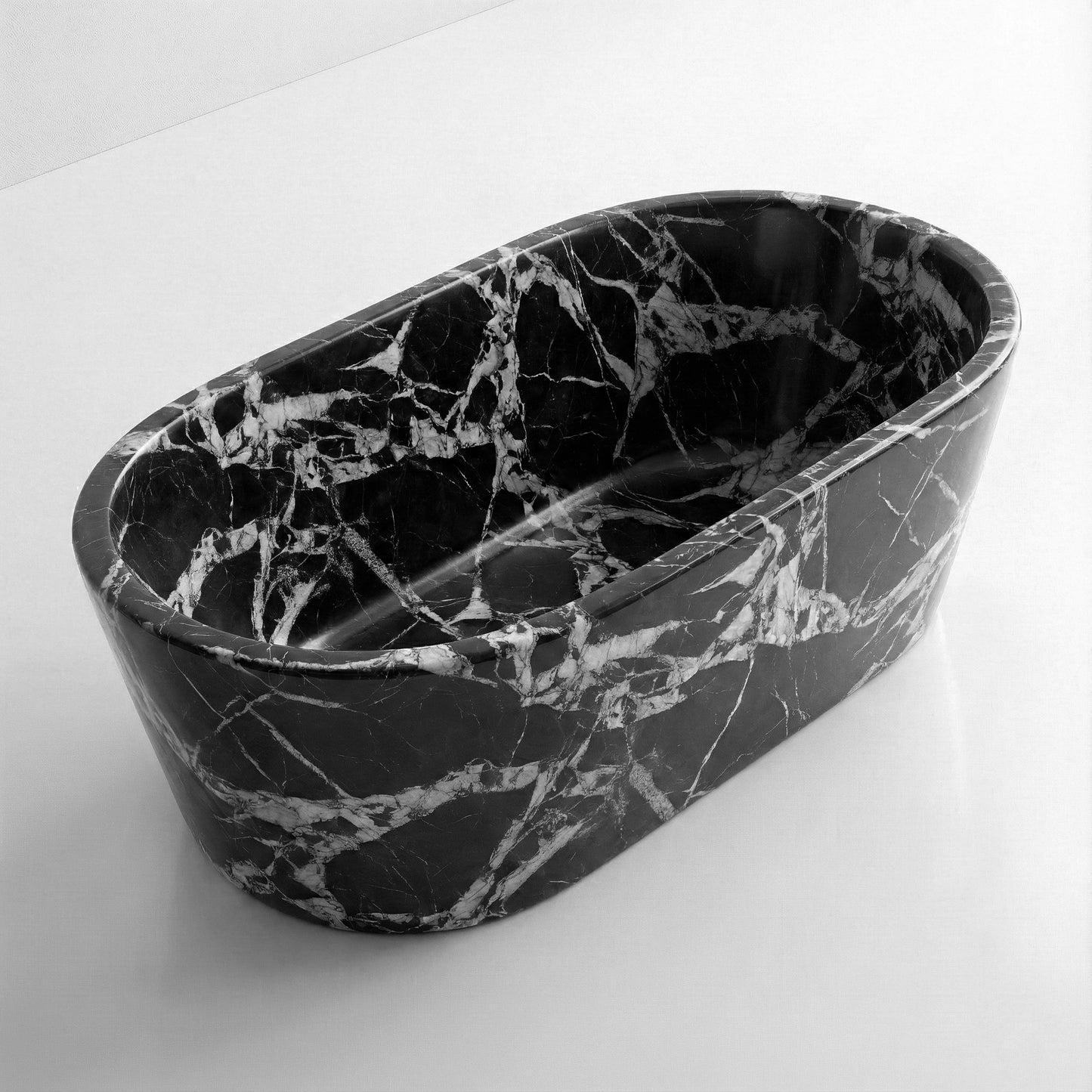 High-angle view of a freestanding oval Grand Antique marble bathtub, displaying a polished finish and bold monochromatic black and white graphic patterns.