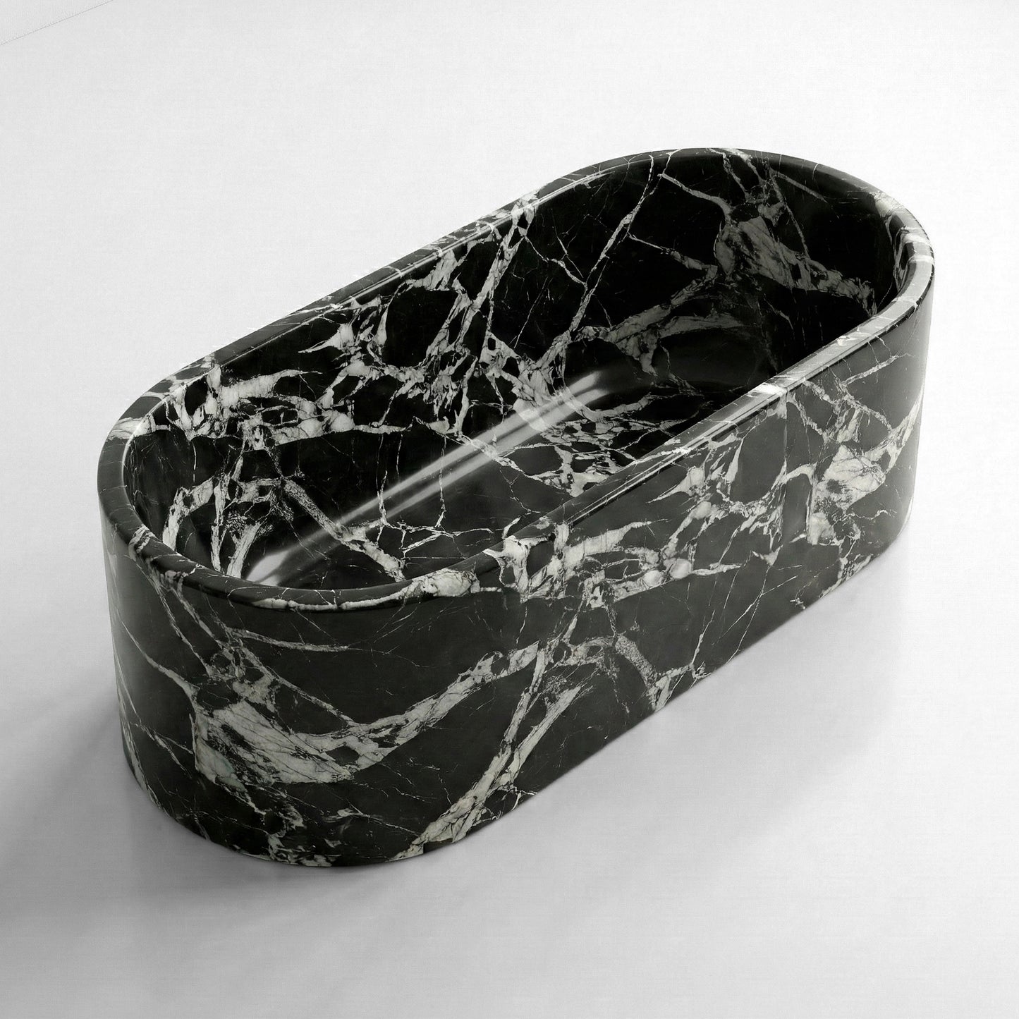 Isometric side view of a Grand Antique marble bathtub featuring a high-contrast black background with jagged white brecciated veining.