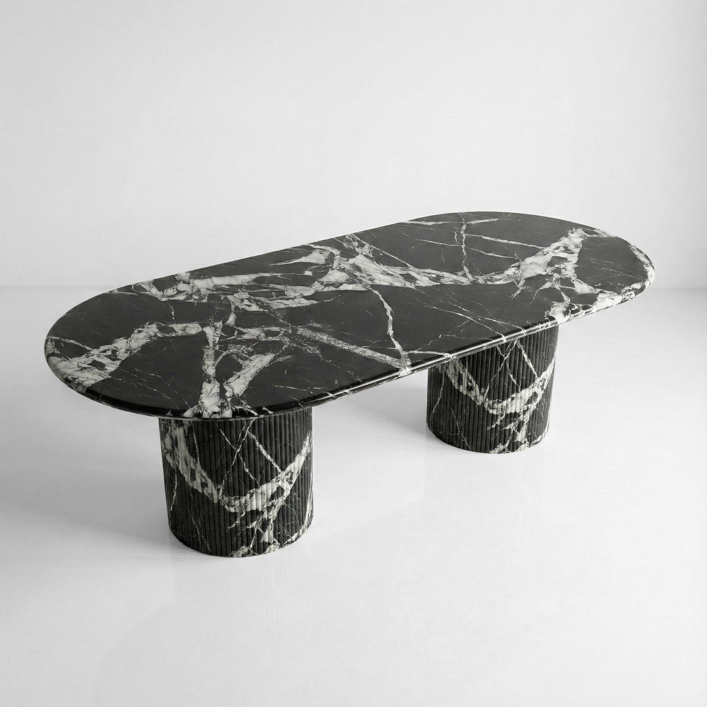 High-angle view of a statement Grand Antique marble dining table with a large oval top and dramatic monochromatic brecciated veining.