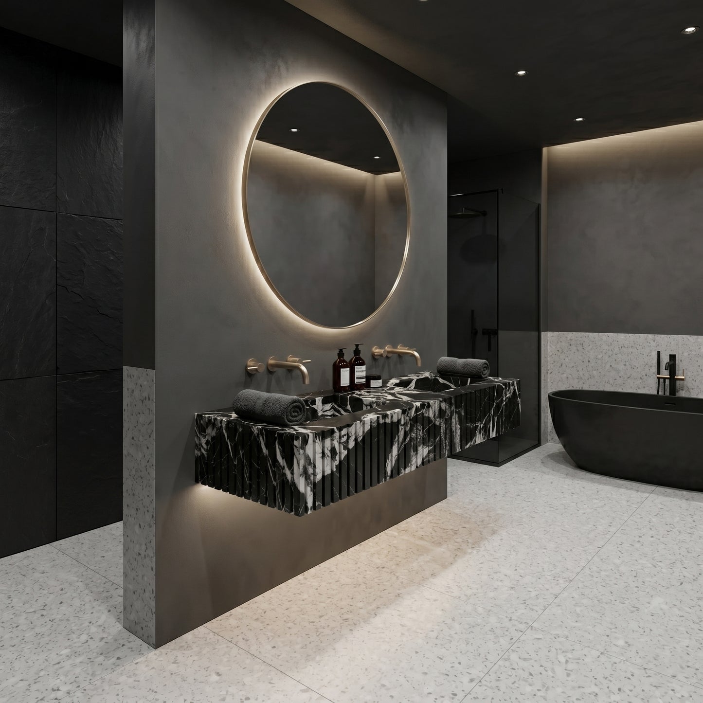Moody modern bathroom suite featuring a statement Grand Antique marble fluted sink, large backlit mirror, and a walk-in shower with matching dark stone accents.