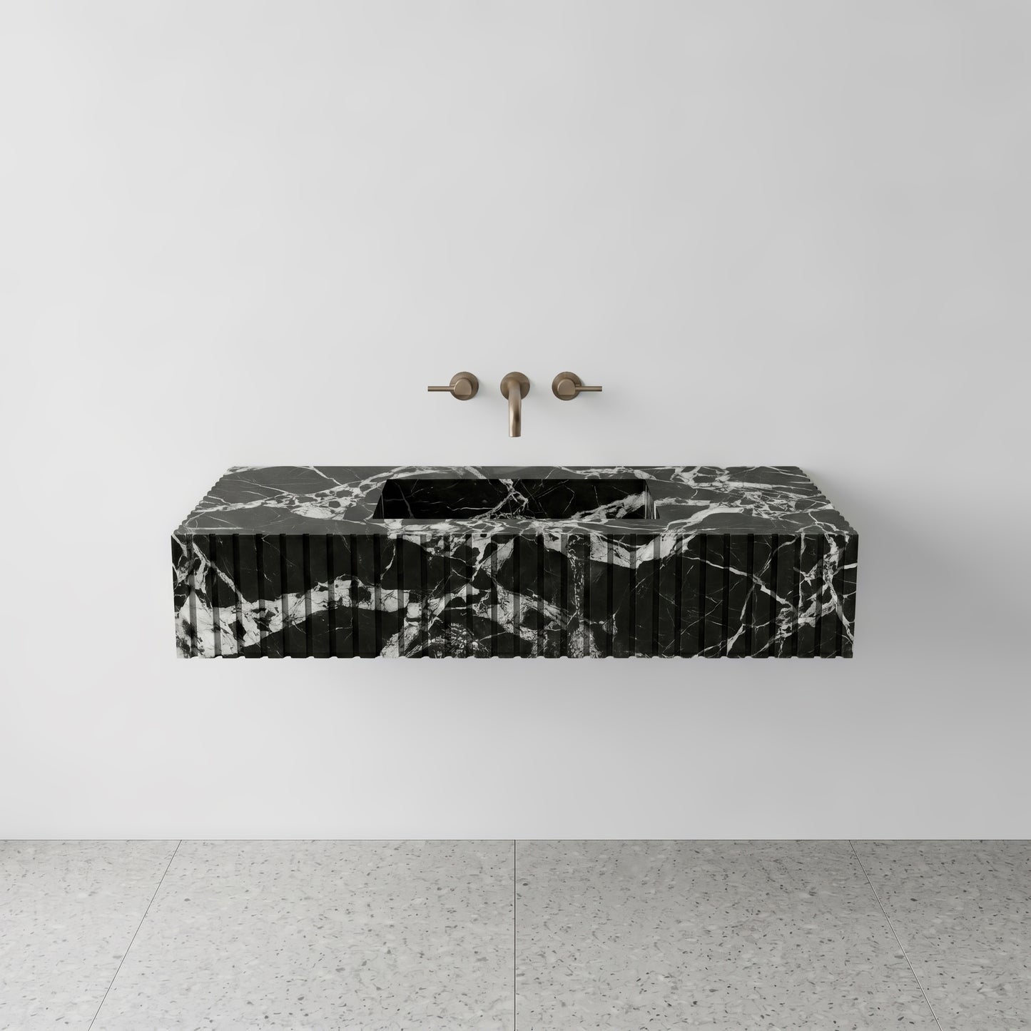 Front studio view of a luxury floating single sink vanity carved from high-contrast Grand Antique black and white marble, featuring a precise fluted apron front design and a wall-mounted brushed bronze faucet.