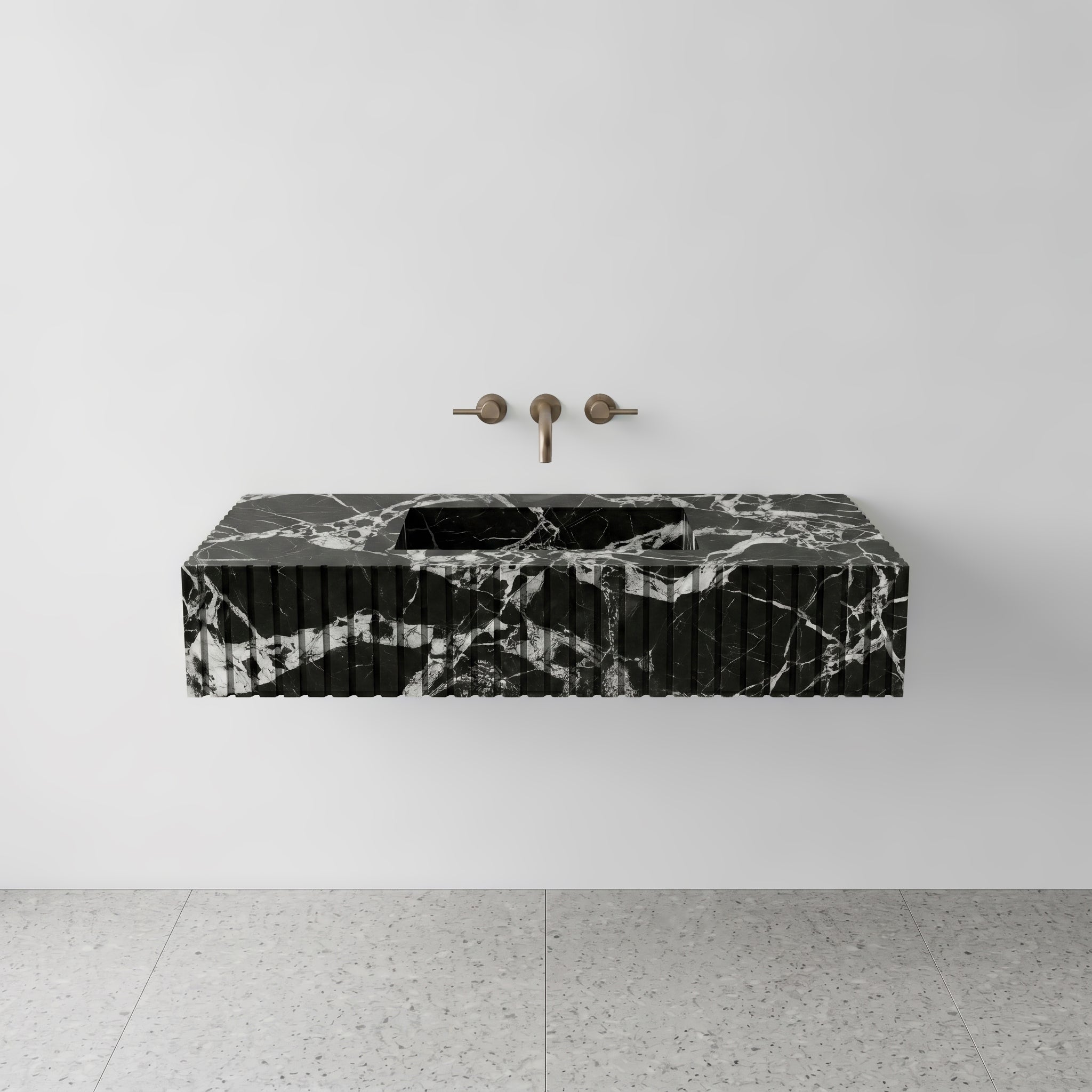 Front studio view of a luxury floating single sink vanity carved from high-contrast Grand Antique black and white marble, featuring a precise fluted apron front design and a wall-mounted brushed bronze faucet.