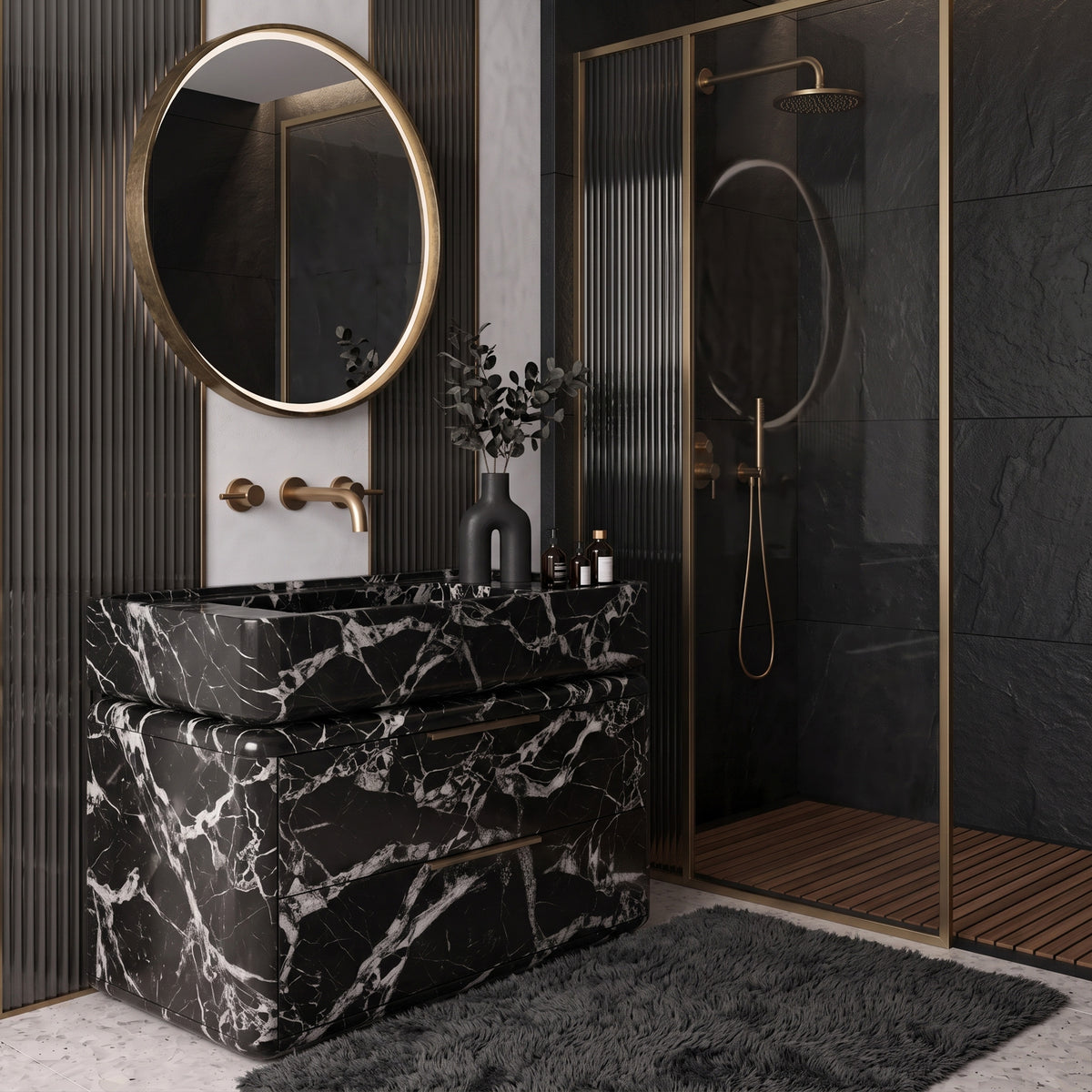 Moody luxury bathroom interior featuring the curved Grand Antique marble double-drawer vanity paired with wall-mounted brass fixtures, a round brass-framed backlit mirror, vertical fluted dark charcoal wall panels with brass accents, a walk-in shower with reeded glass, and a plush charcoal rug on terrazzo flooring.