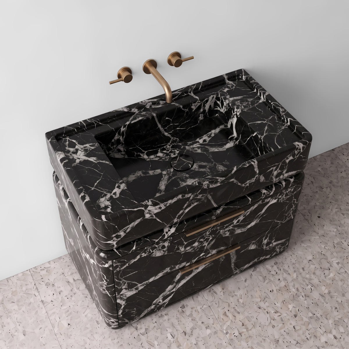 High-angle perspective view of the Grand Antique marble double-drawer vanity, highlighting the integrated trough sink with a matching stone drain cover, raised perimeter border, rounded drawer corners, brushed brass linear pulls, and bold monochrome marble patterns.
