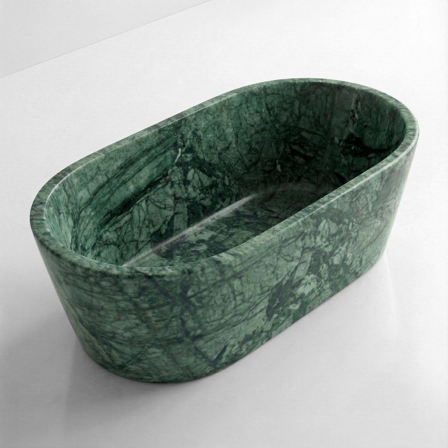 High-angle view of a freestanding oval Green Guatemala marble bathtub, showcasing deep emerald green stone with characteristic dark serpentine veining.
