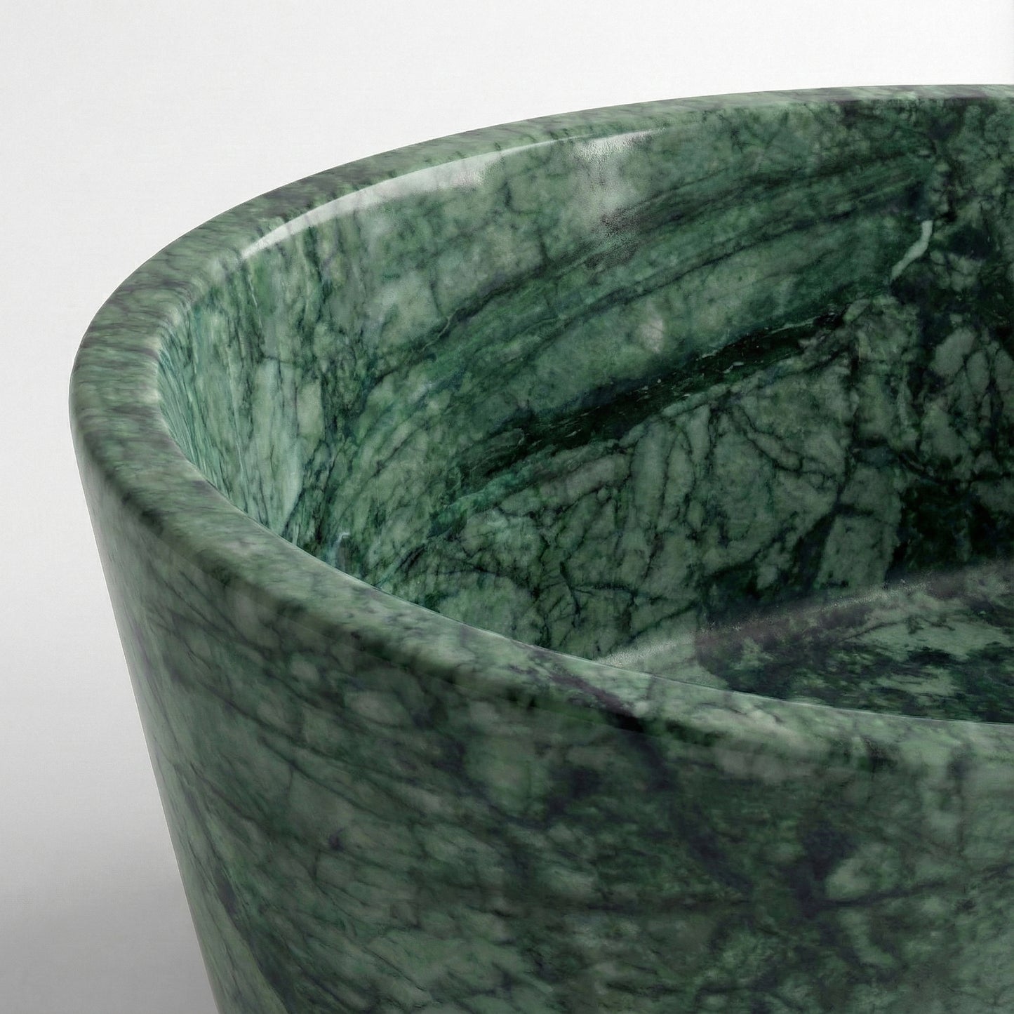 Close-up detail of a Green Guatemala bathtub rim highlighting the intricate web of dark green veins and polished natural stone texture.