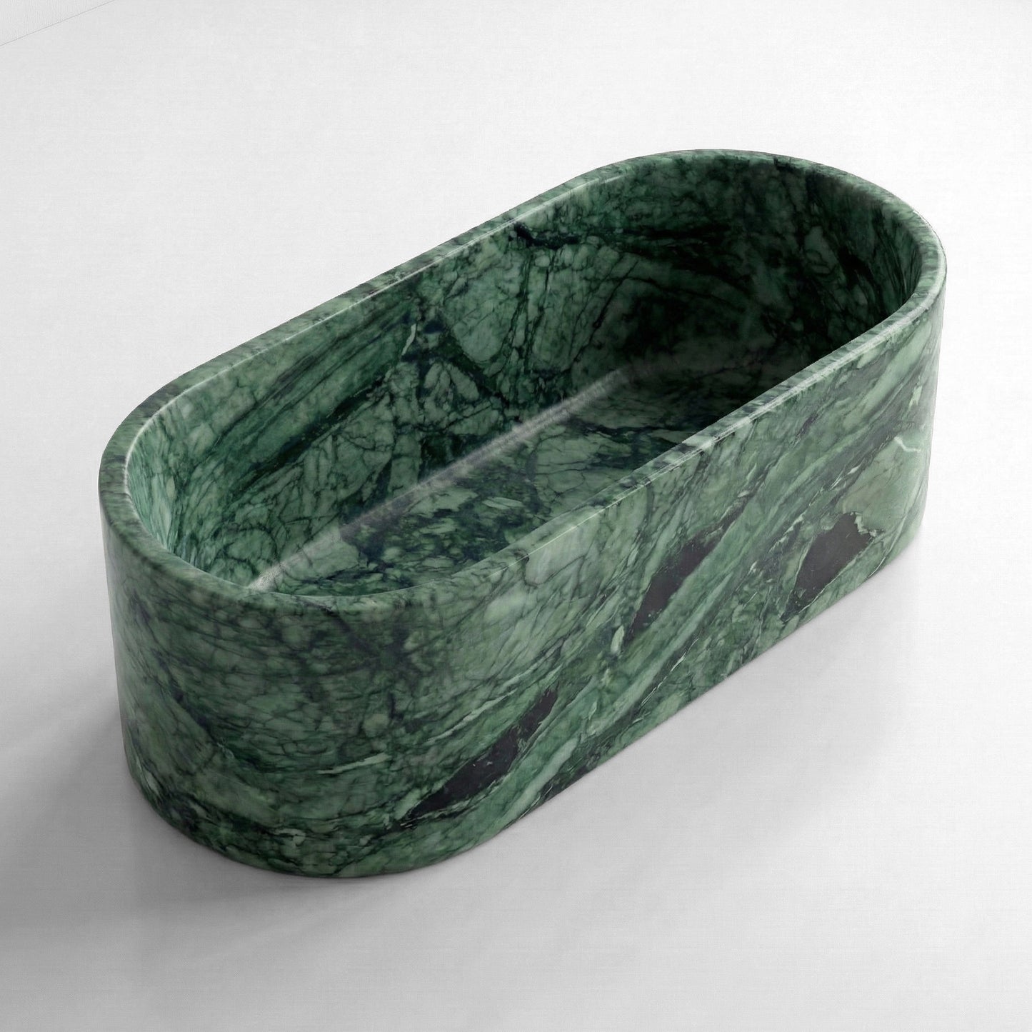 Isometric side view of a deep-soaking Green Guatemala natural stone bathtub, emphasizing its seamless oval shape and rich color depth.
